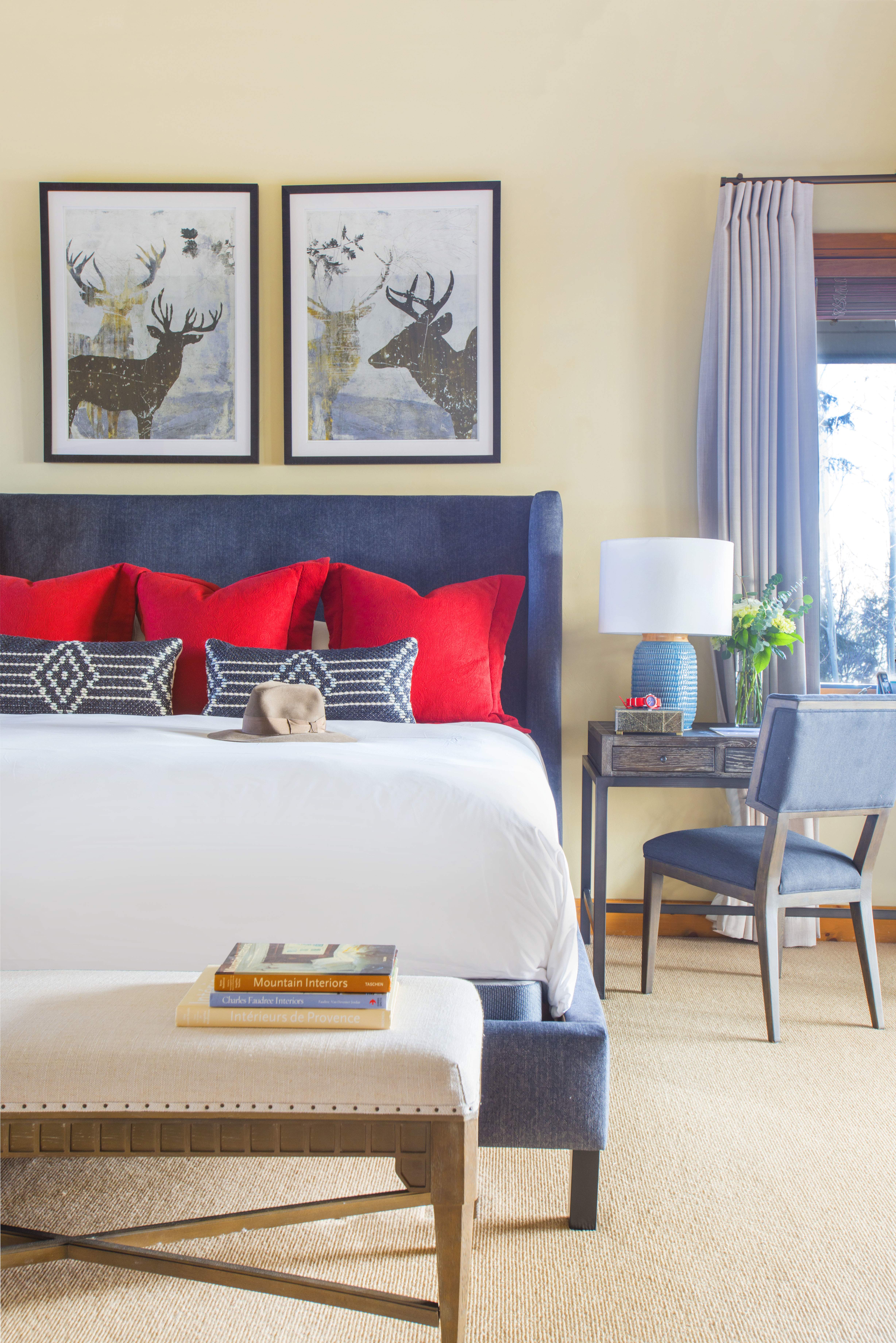 Exclusive Resorts mountain home bedroom in Beaver Creek, Colorado with red and blue decor and nature-themed artwork.