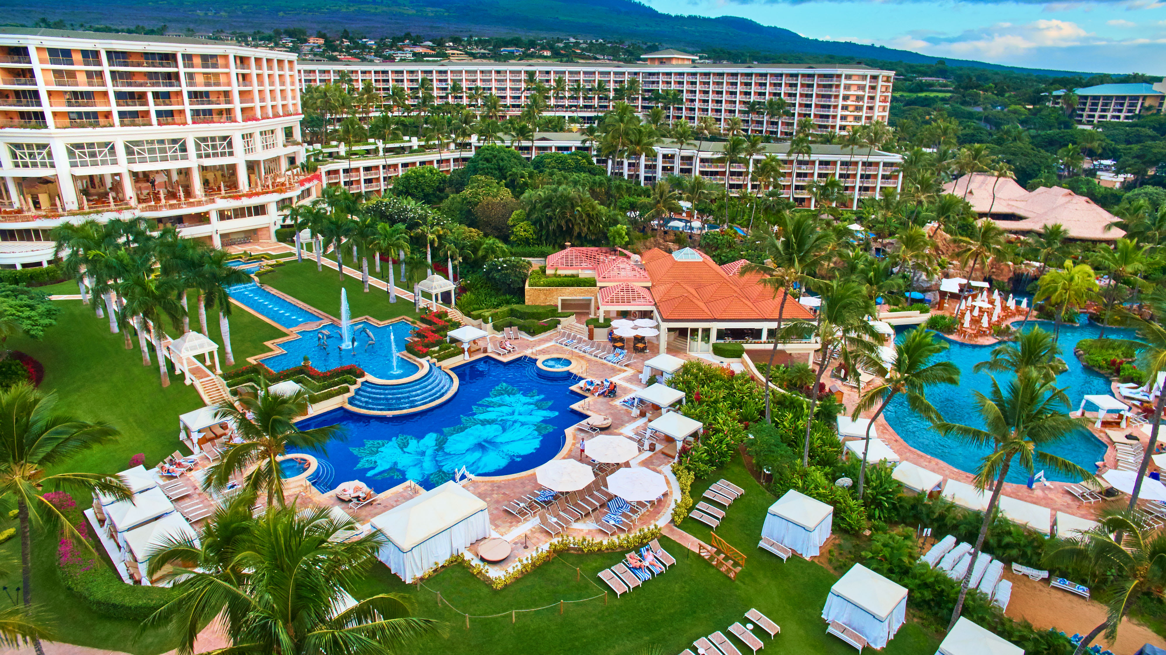 Resort pool with fountains, loungers, and tropical gardens at Grand Wailea Resort in Maui.