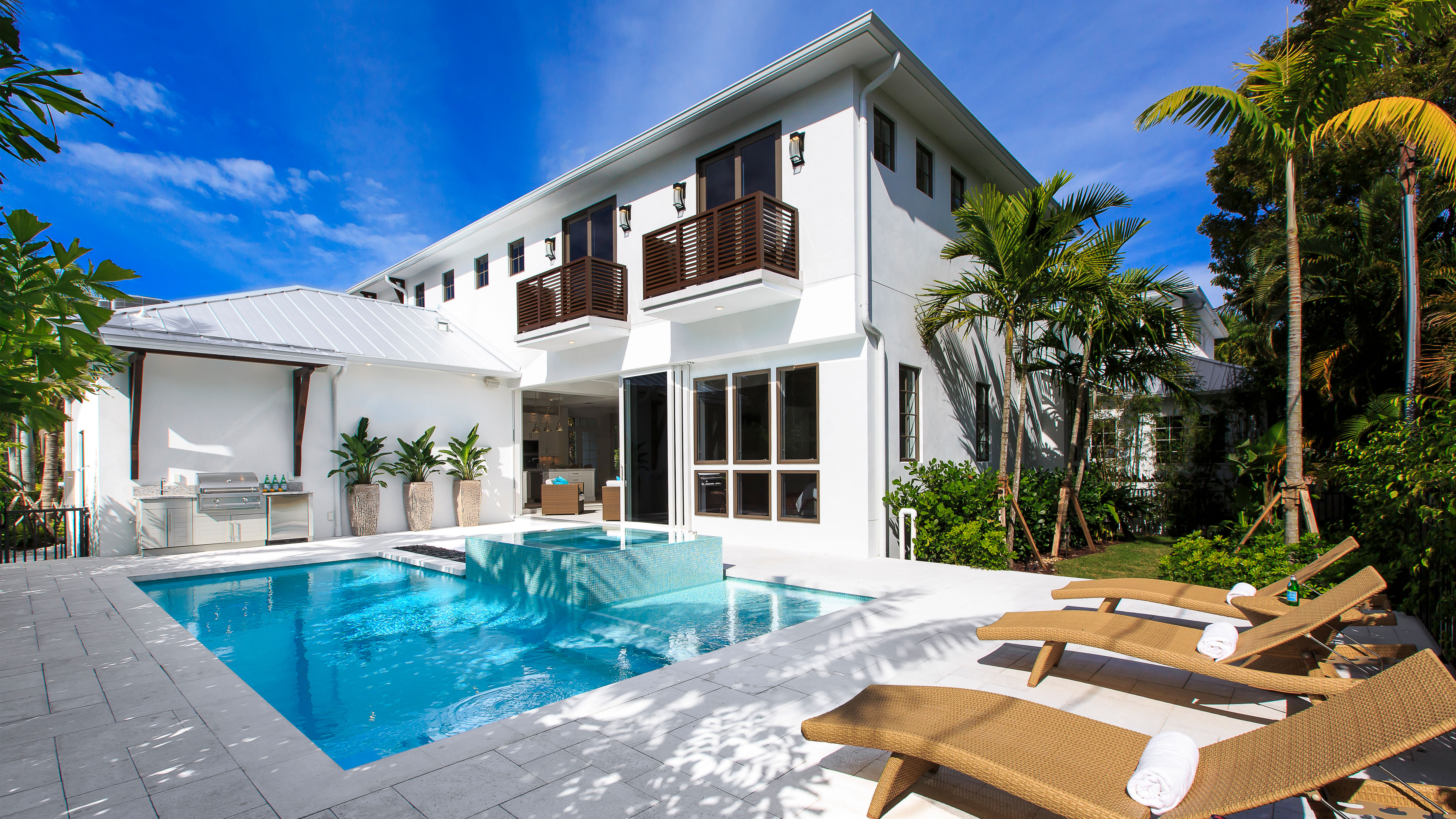 Exclusive Resorts luxury home in Naples, Florida, featuring a private swimming pool and sun loungers.