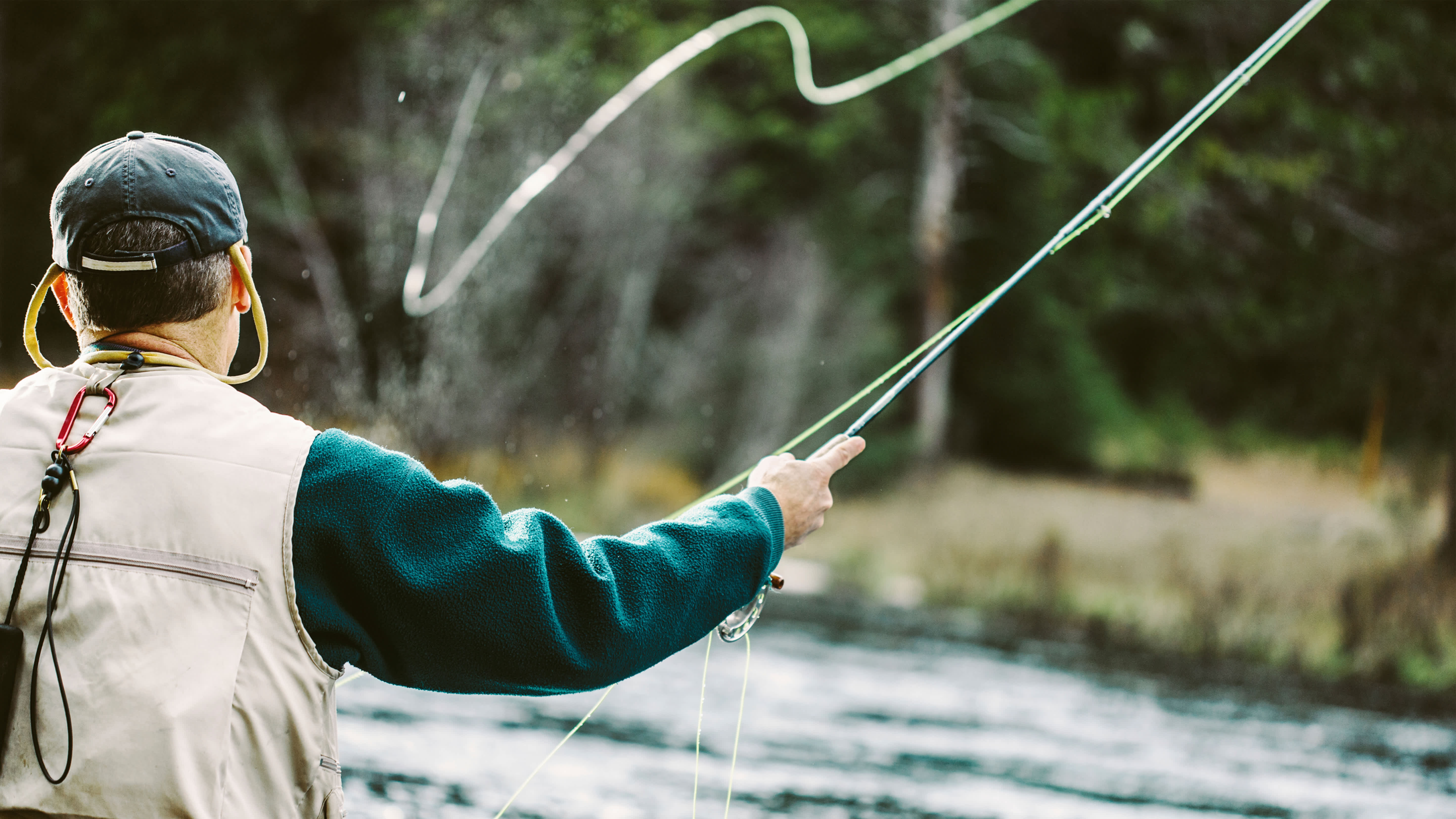 A man fly fishing in a river in Deer Valley, Utah.