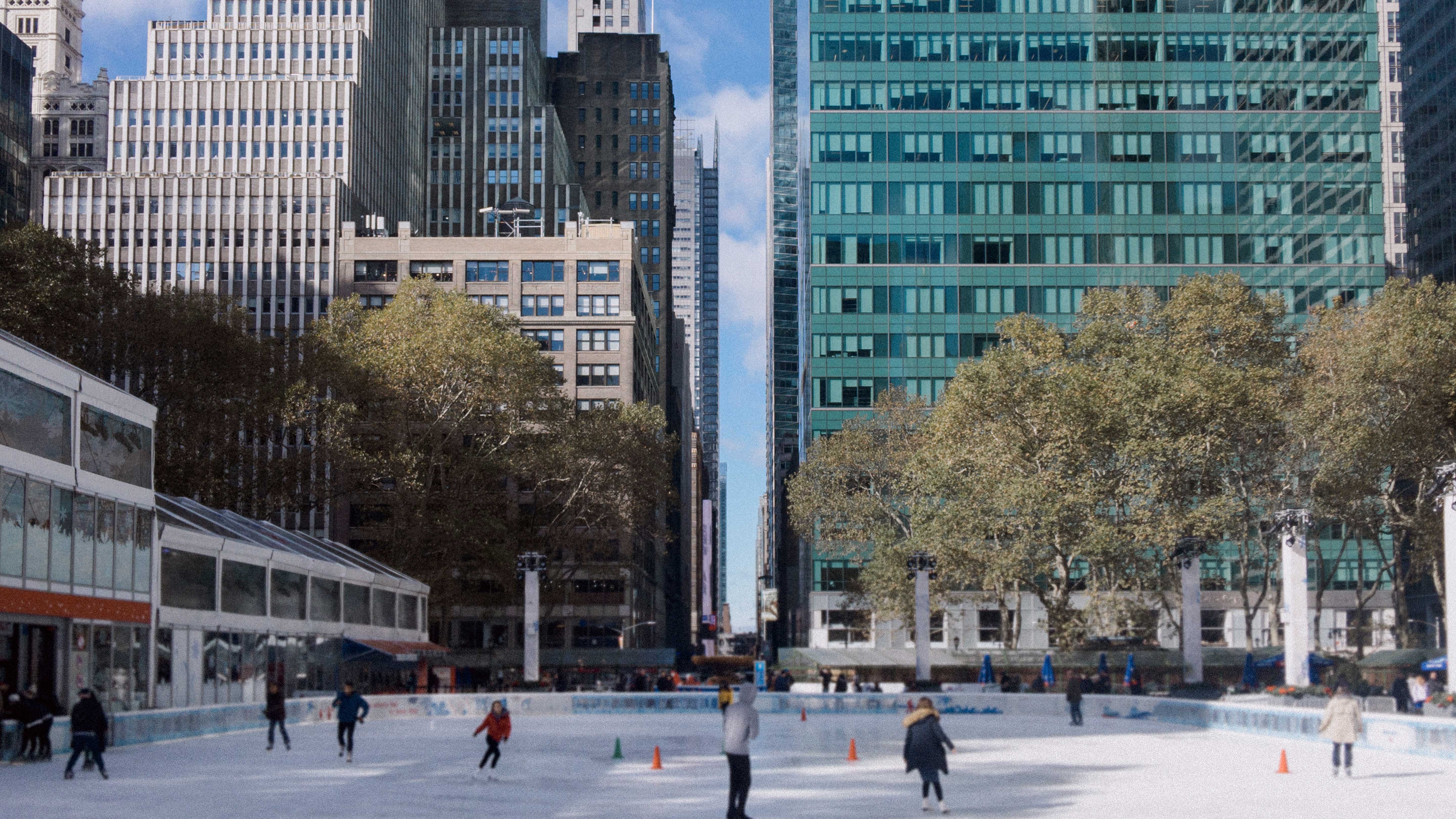 Outdoor ice-skating rink bustling with skaters in New York City.