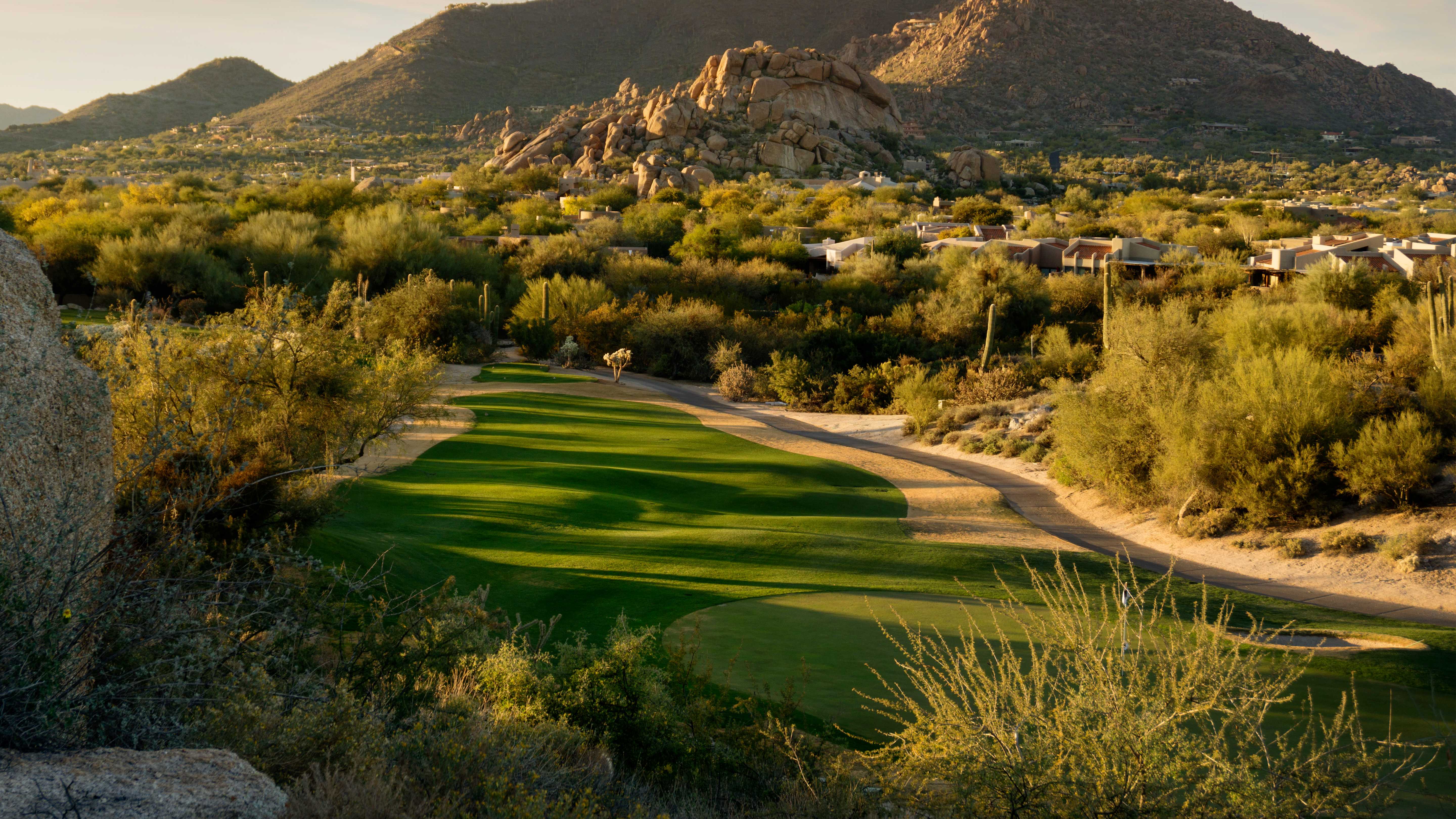 Scenic view of the fairways at Troon Golf Club near Exclusive Resorts properties in Scottsdale, with desert mountains in the backdrop.