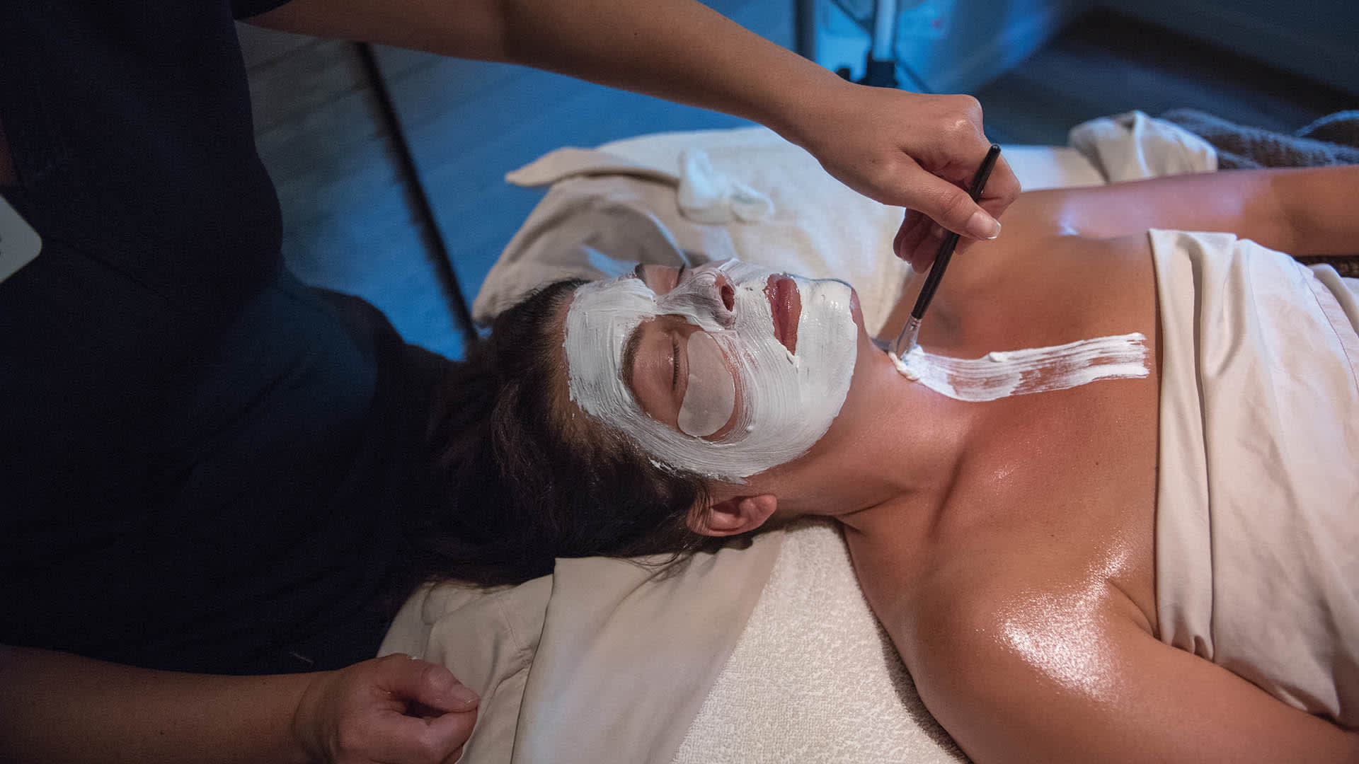 A woman receiving a facial at a spa.