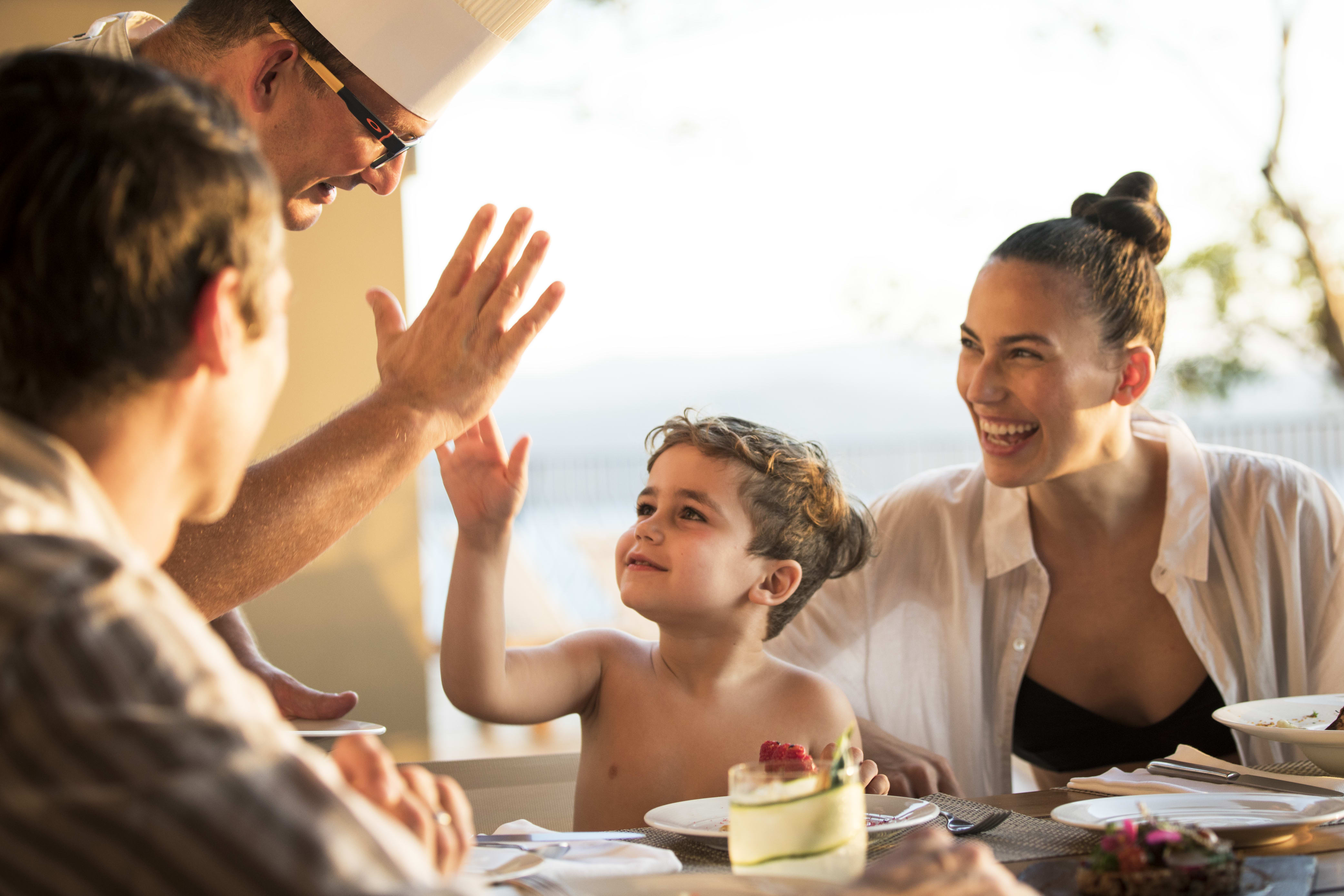 Young boy high-fiving private chef.