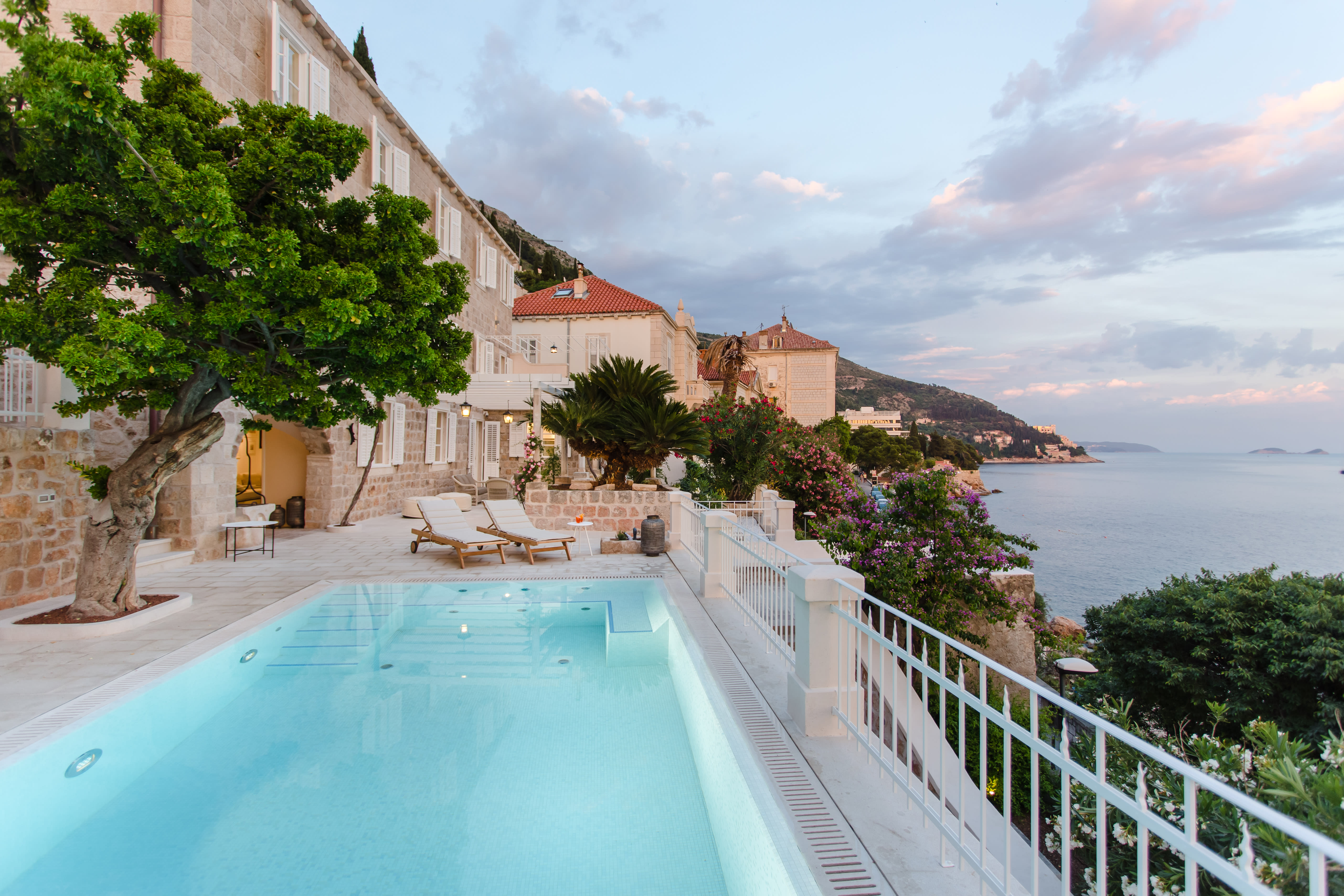 Exclusive Resorts' private villa in Dubrovnik, Croatia, with a serene pool overlooking the Adriatic Sea and historic architecture.