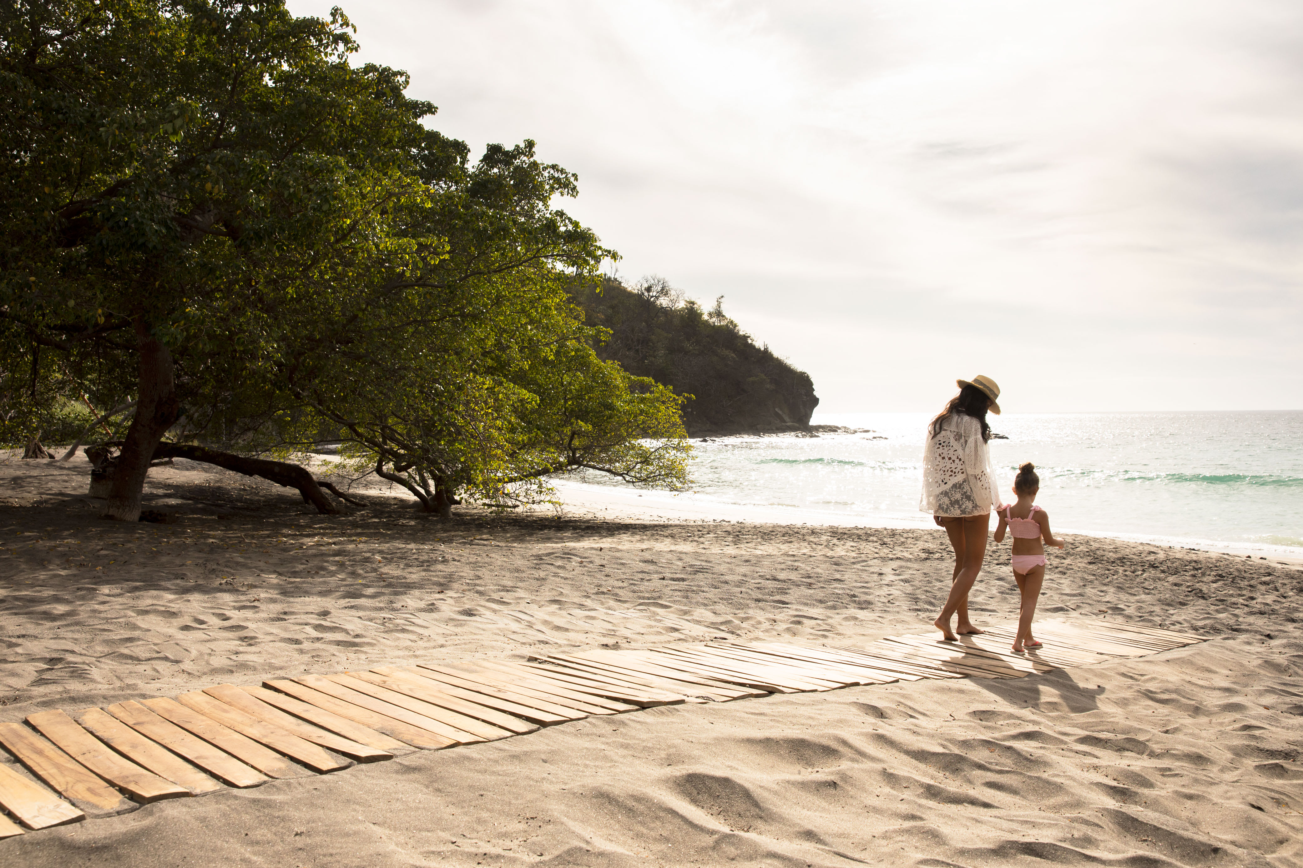 Mother and her daughter walking at Peninsula Papagayo beach club in Costa Rica.