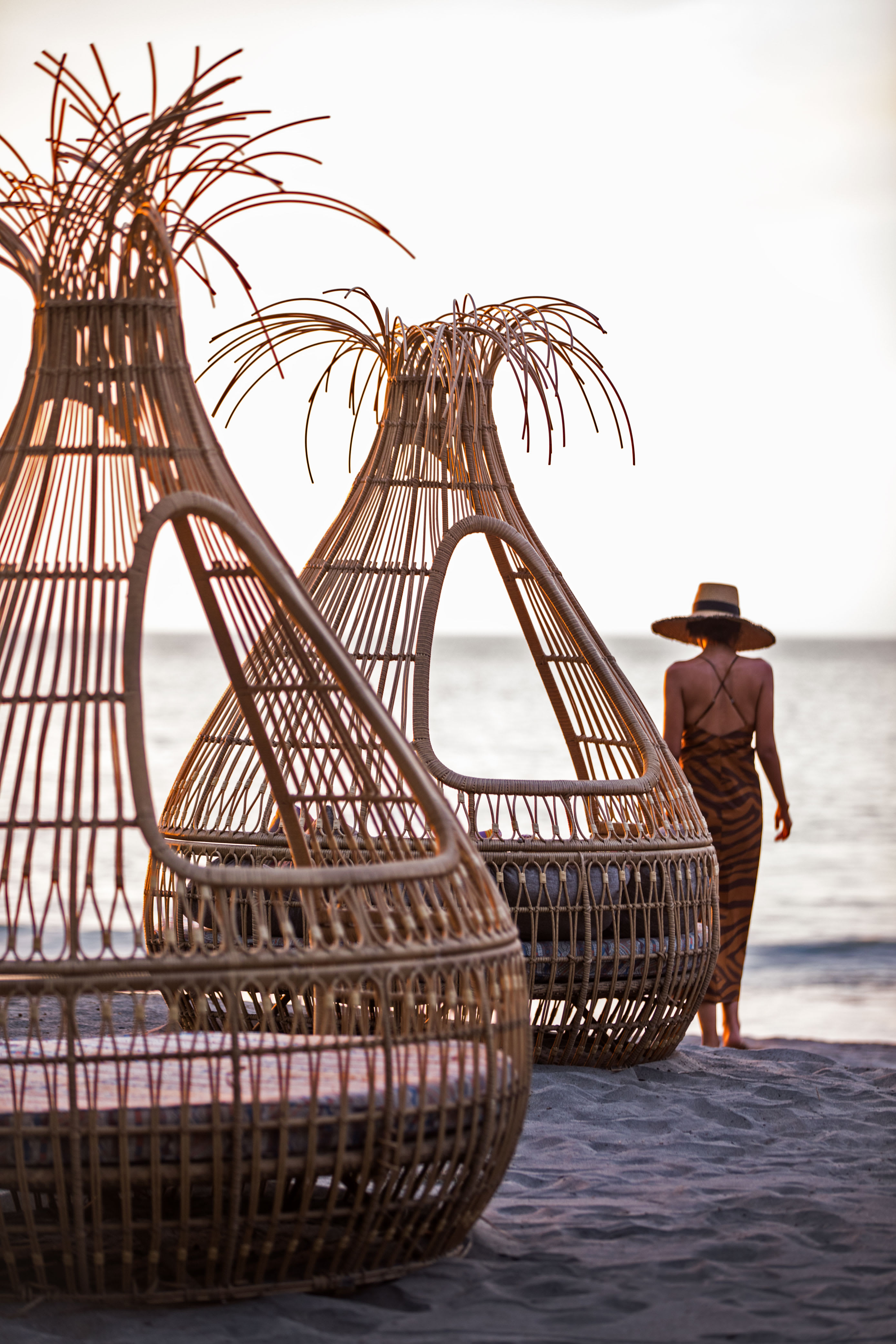 A woman walking next to cabanas on the beach in Costa Rica.