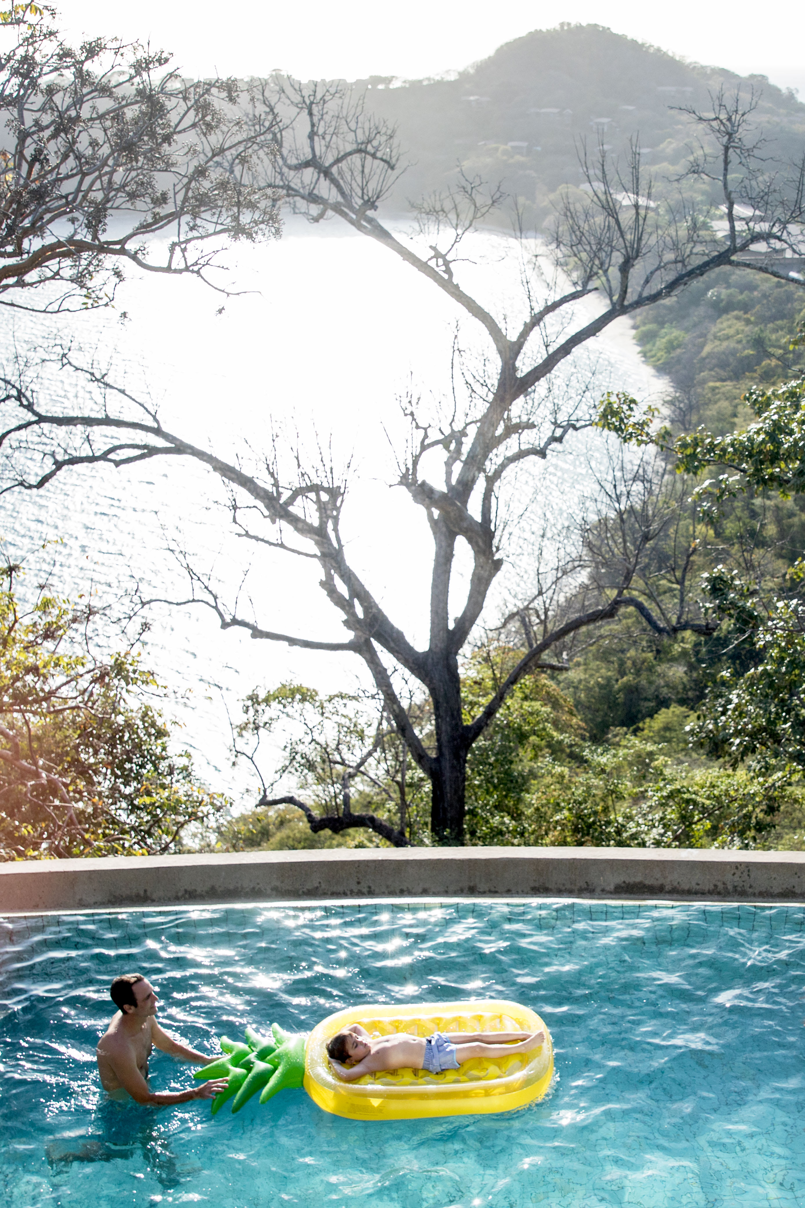 A member of an Exclusive Resorts vacation club enjoying time with their child in a pool at a villa in Peninsula Papagayo, Costa Rica.