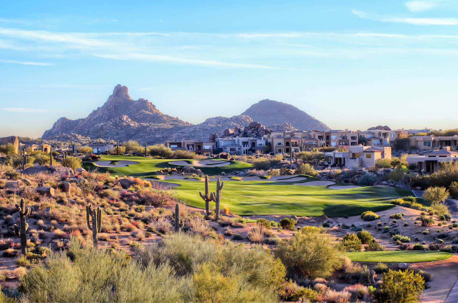 Luxury homes overlooking a golf course with mountains in the background in Scottsdale, Arizona.