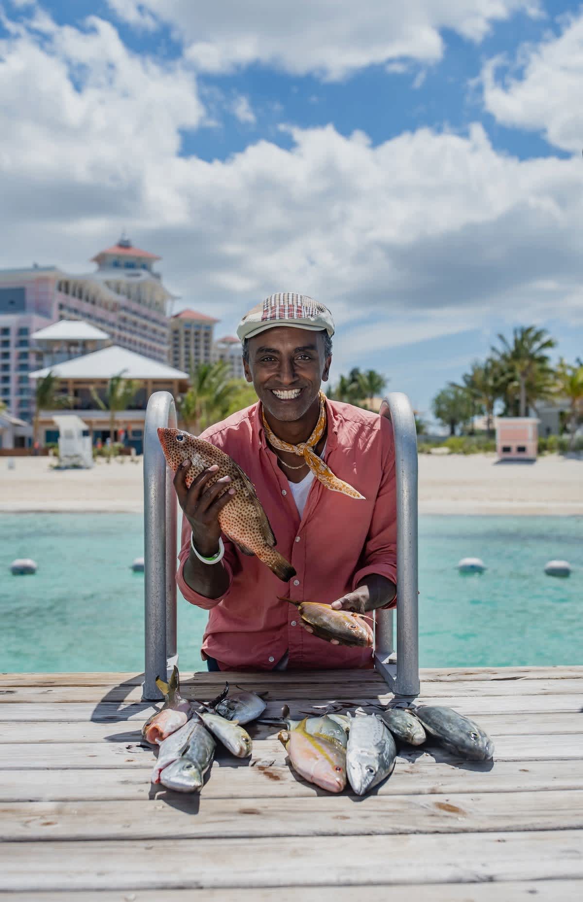 A man holding fish by the water in Baha Mar, Bahamas.