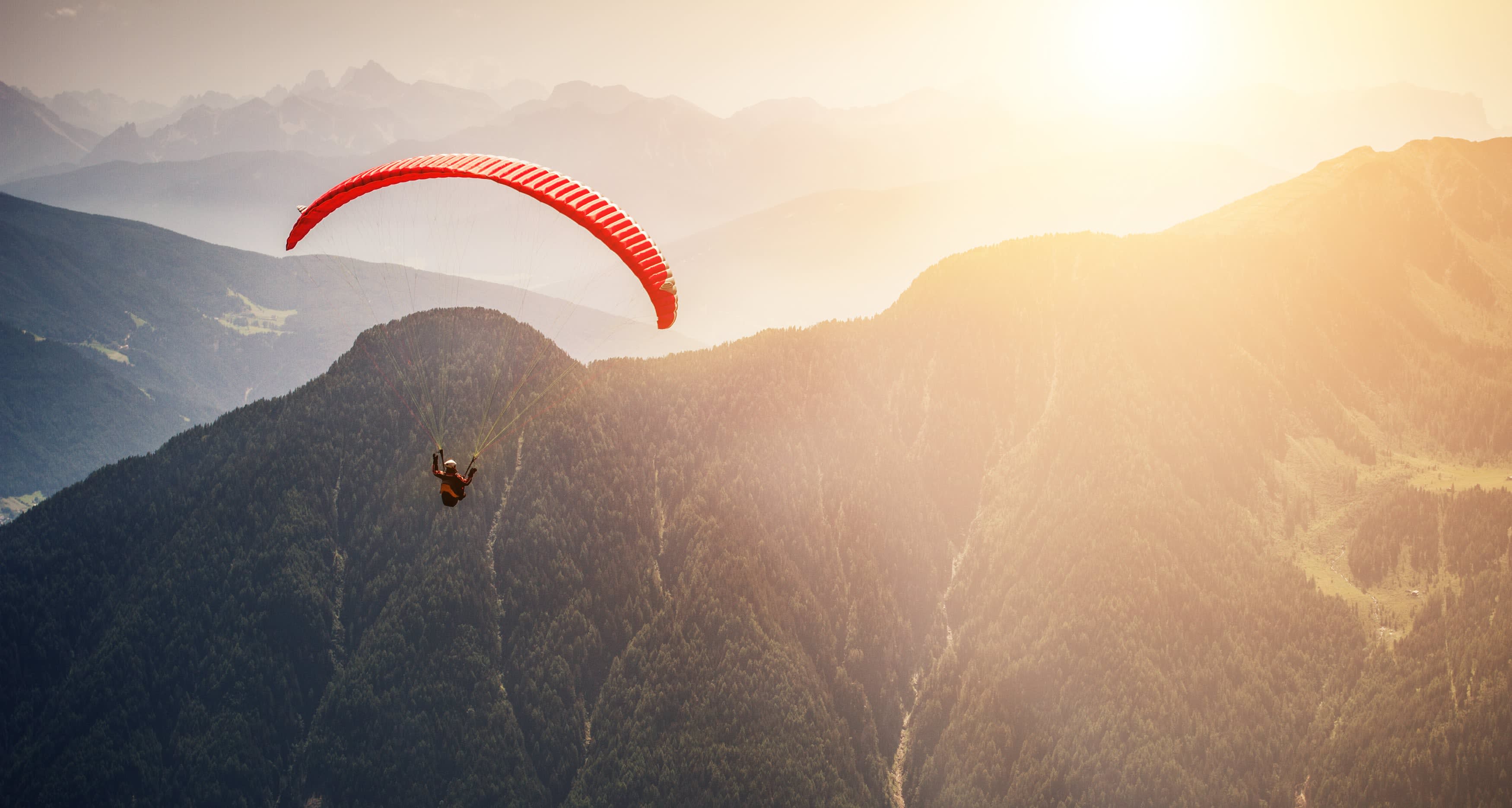 A man paragliding near a mountain in Wyoming.