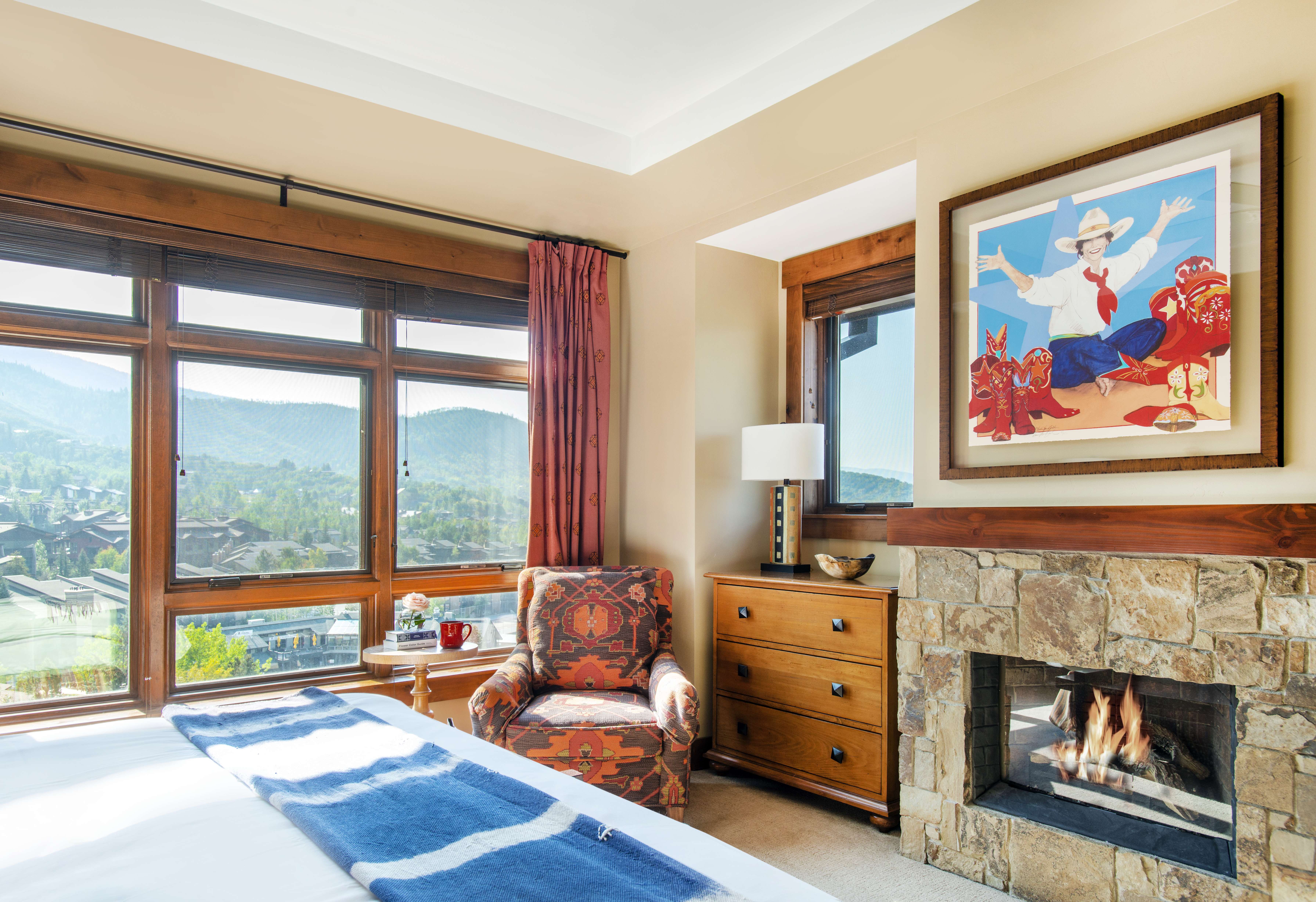 Cozy bedroom with a mountain view and a fireplace in an Exclusive Resorts property at One Steamboat Place.
