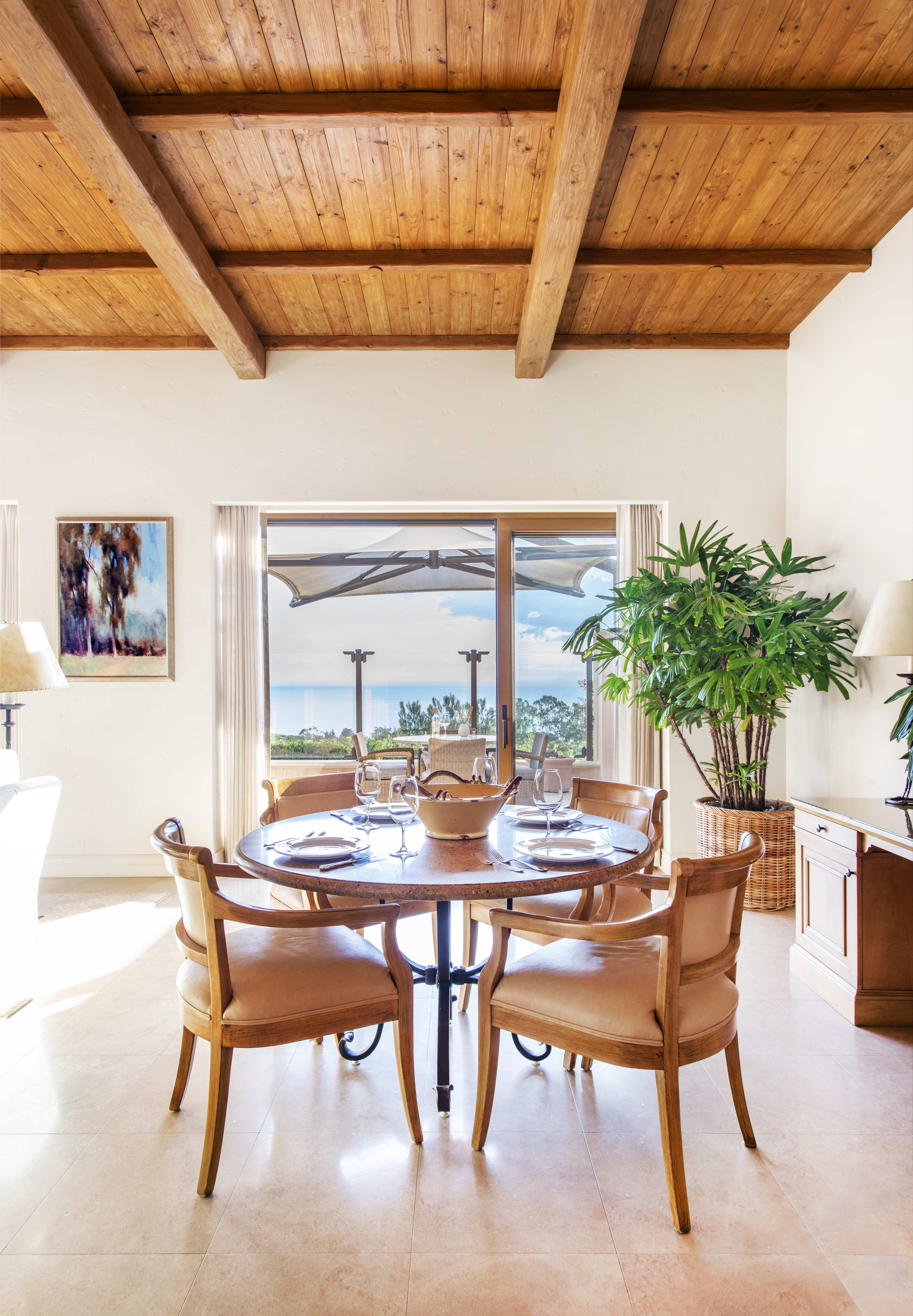 Dining room set for a meal at an Exclusive Resorts property at Pelican Hill Resort, featuring elegant chairs and oceanfront views.