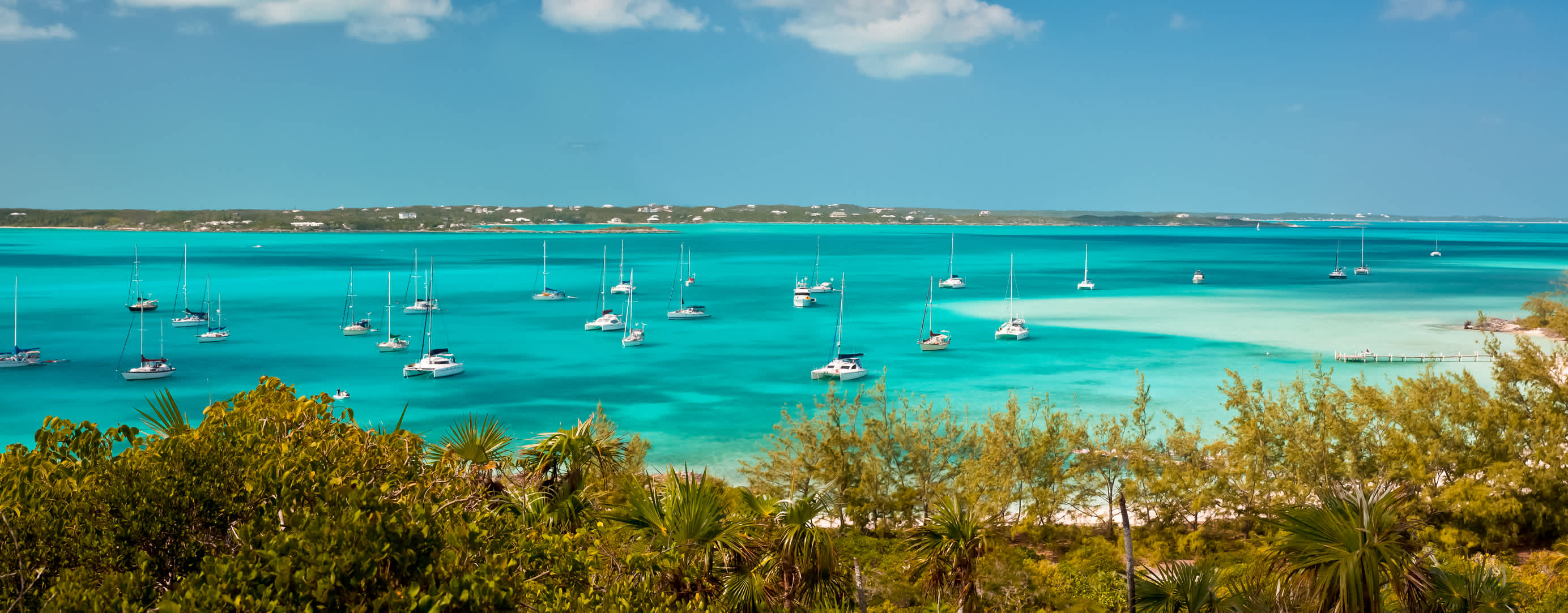 Several sailboats and yachts on a cay in The Bahamas.