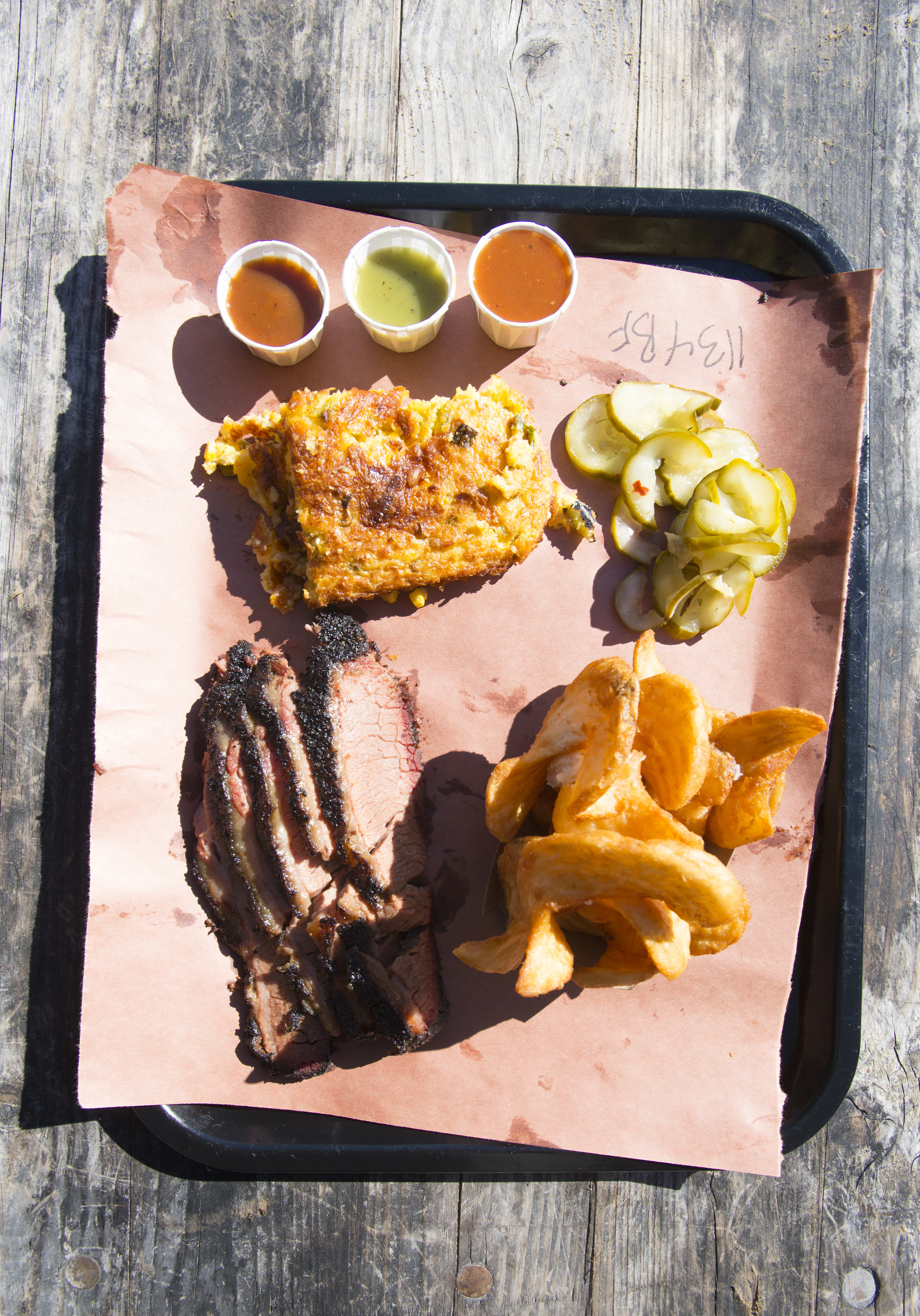 A plate of barbeque food on a wooden table.