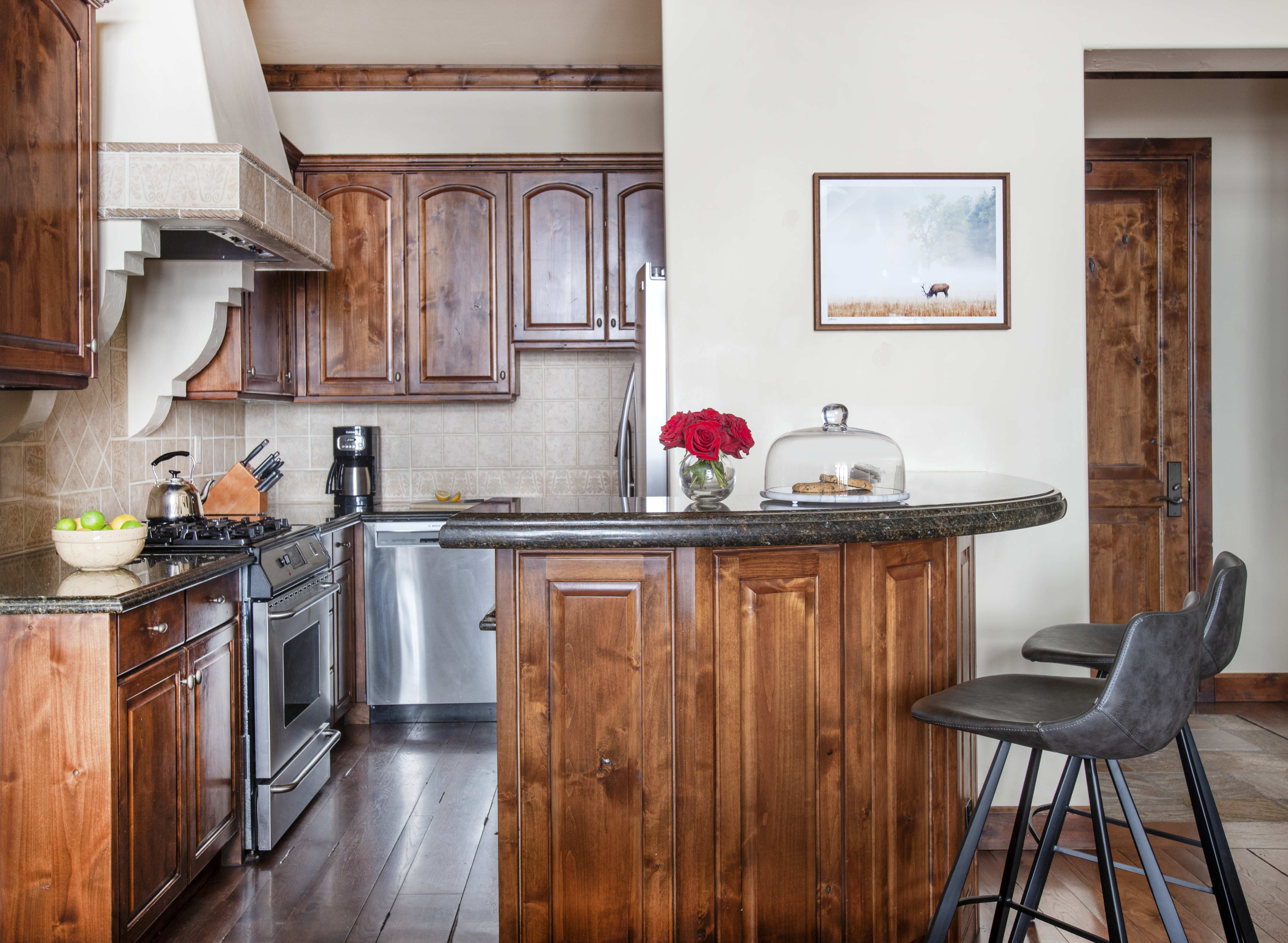 Kitchen with wooden cabinetry and modern appliances at Exclusive Resorts property Les Saisons in Sun Valley.