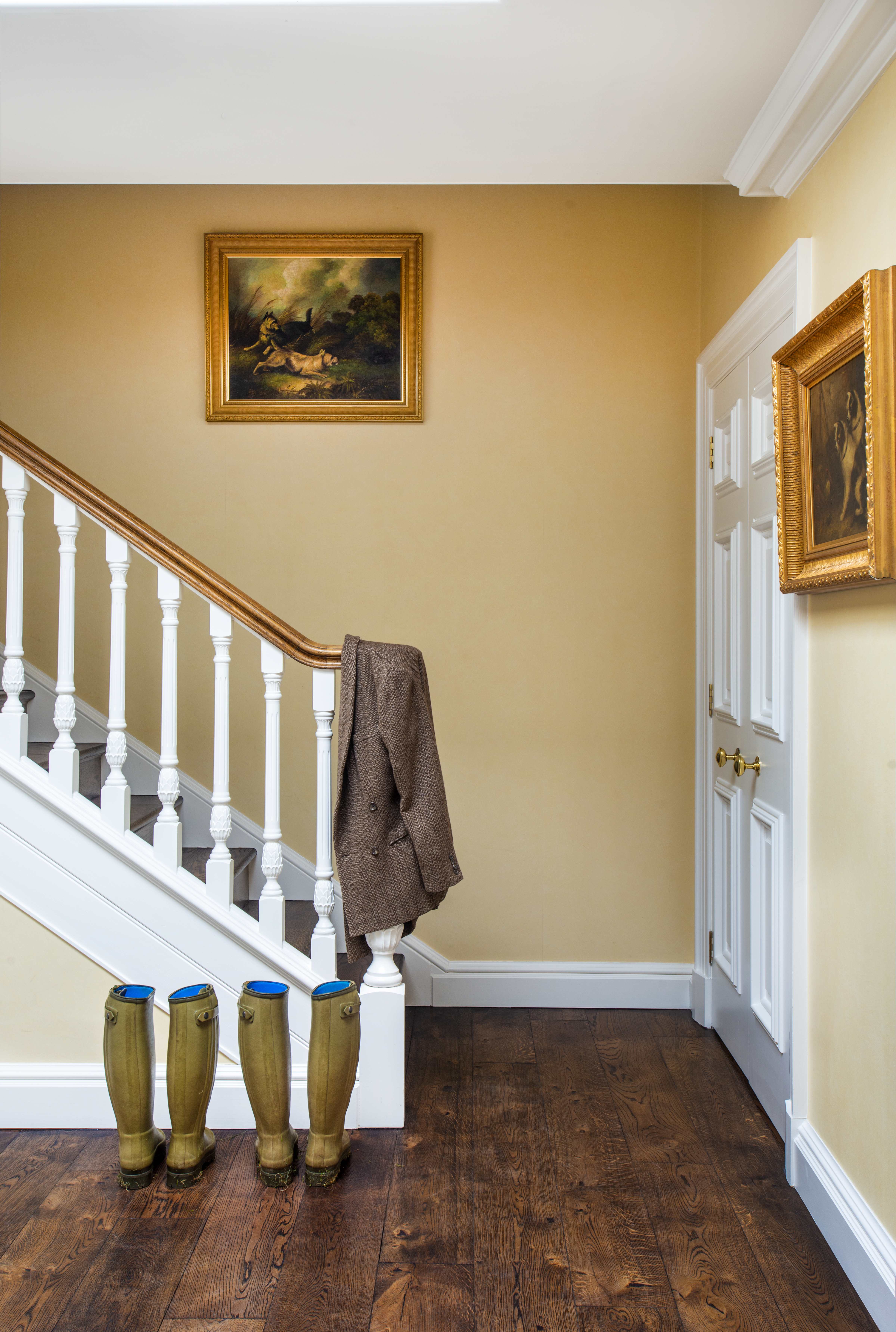 An entryway to a private home with paintings on the wall.