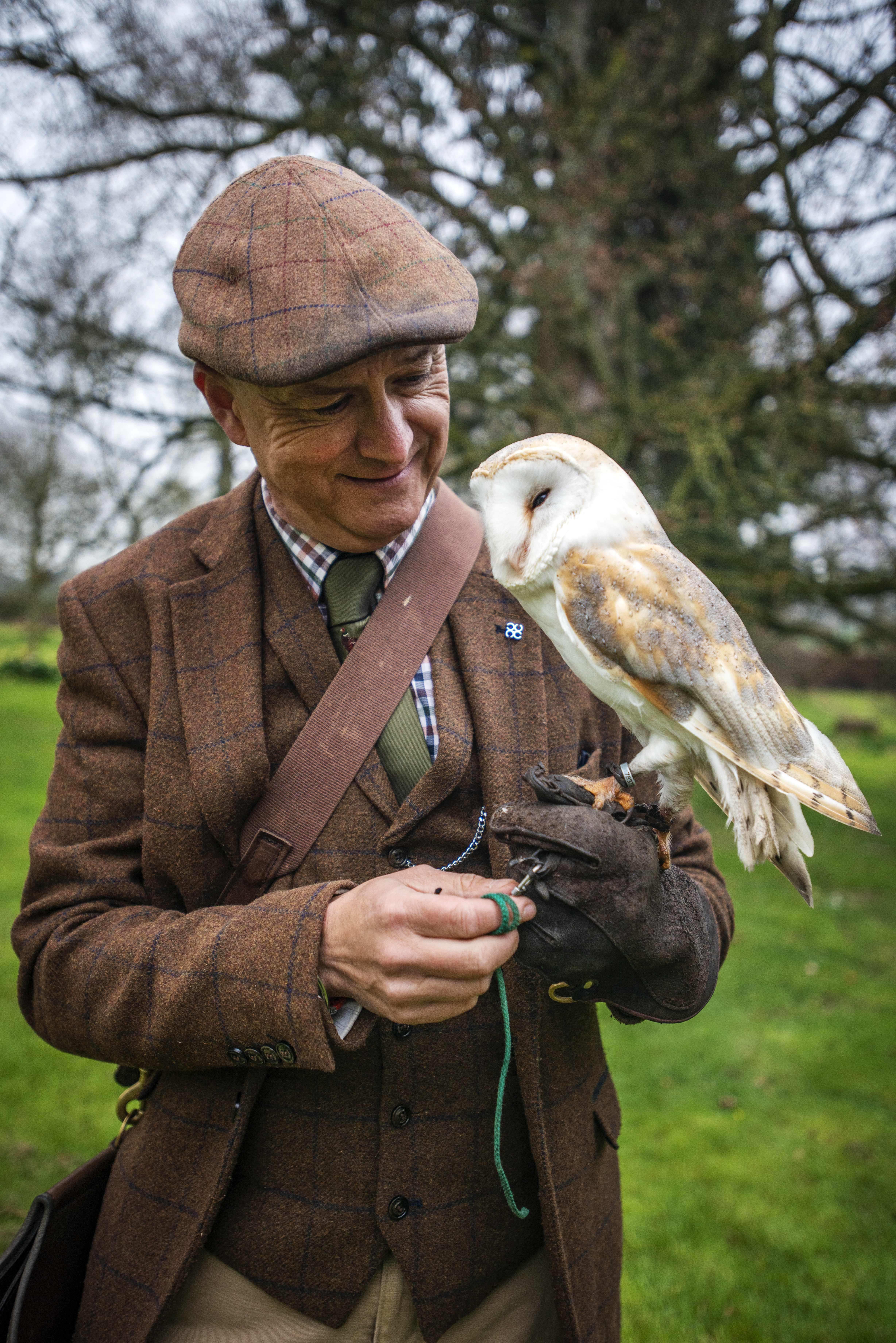 A falconer handling an owl.