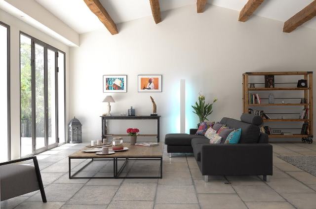 Exclusive Resorts' Provence villa with a modern living room featuring exposed wooden beams and natural light.