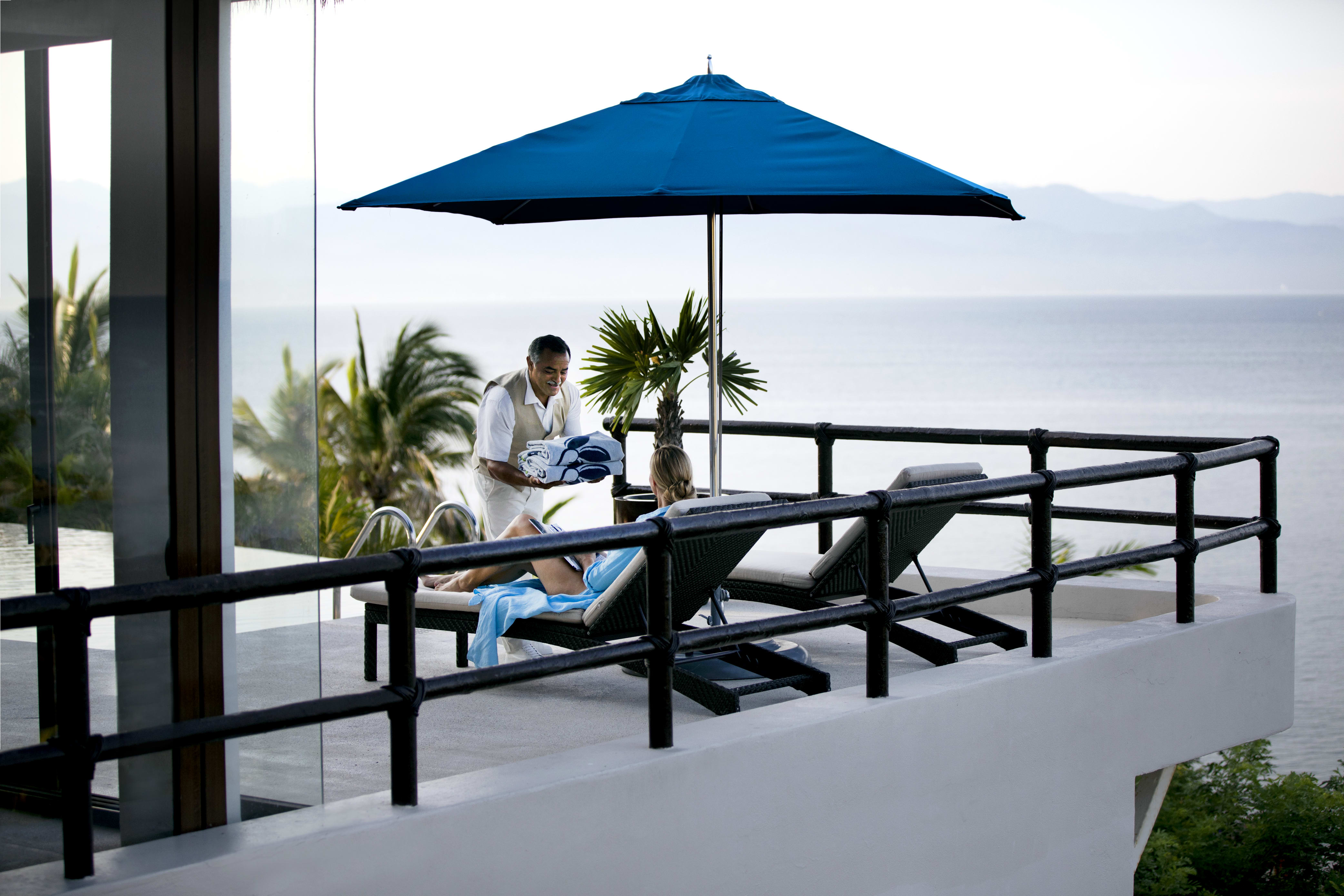 Exclusive Resorts vacation club member enjoying poolside service at a private home in Real del Mar, Mexico.