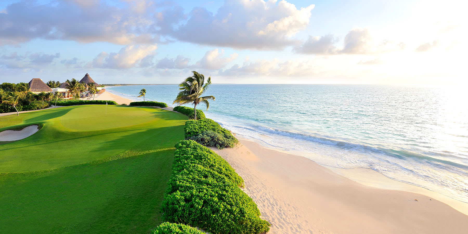 A golf course next to the beach, near Exclusive Resorts properties at the Rosewood Mayakoba Resort.