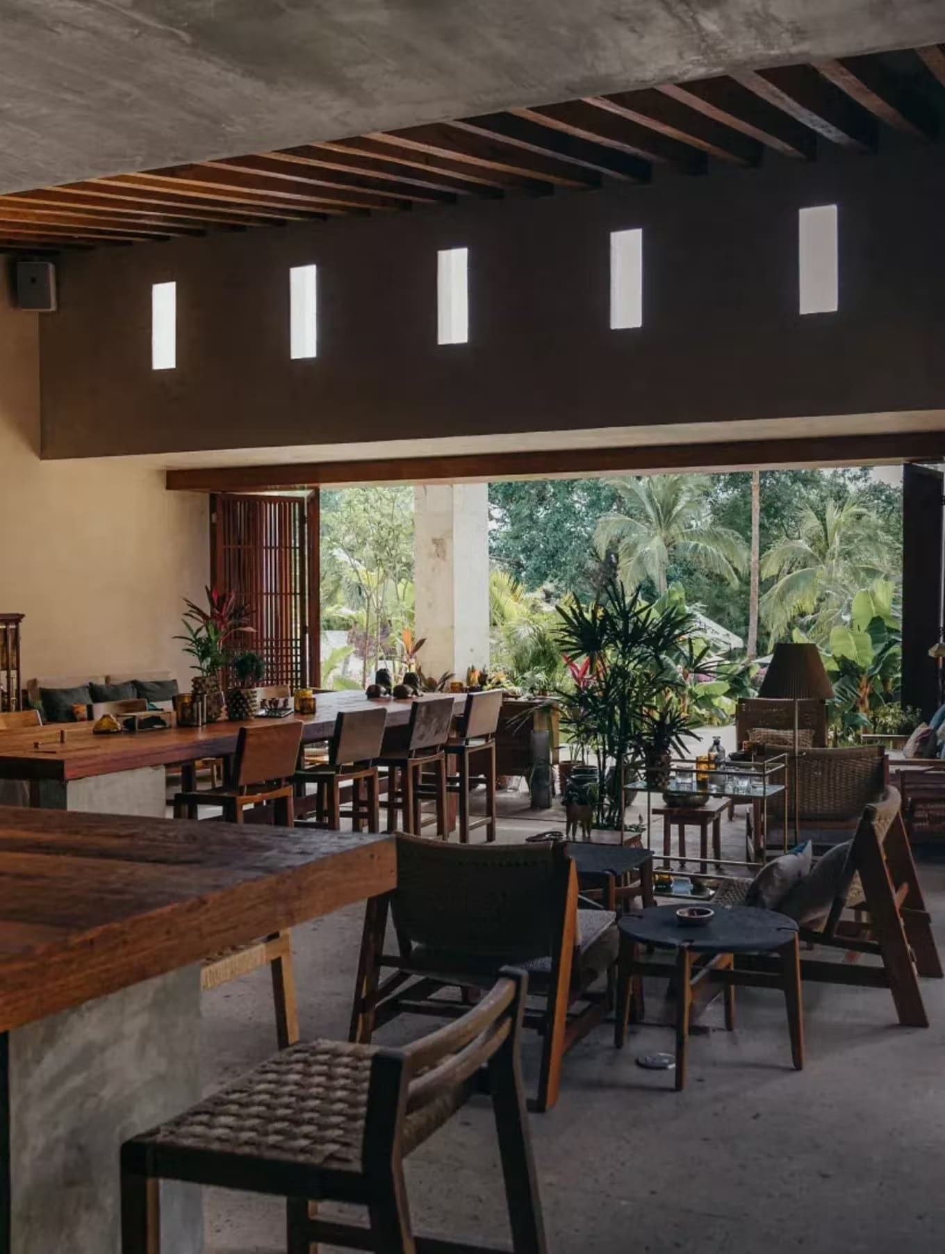Zapote Bar in Rivera Maya showcasing a relaxed and natural atmosphere with open-air seating and lush greenery.