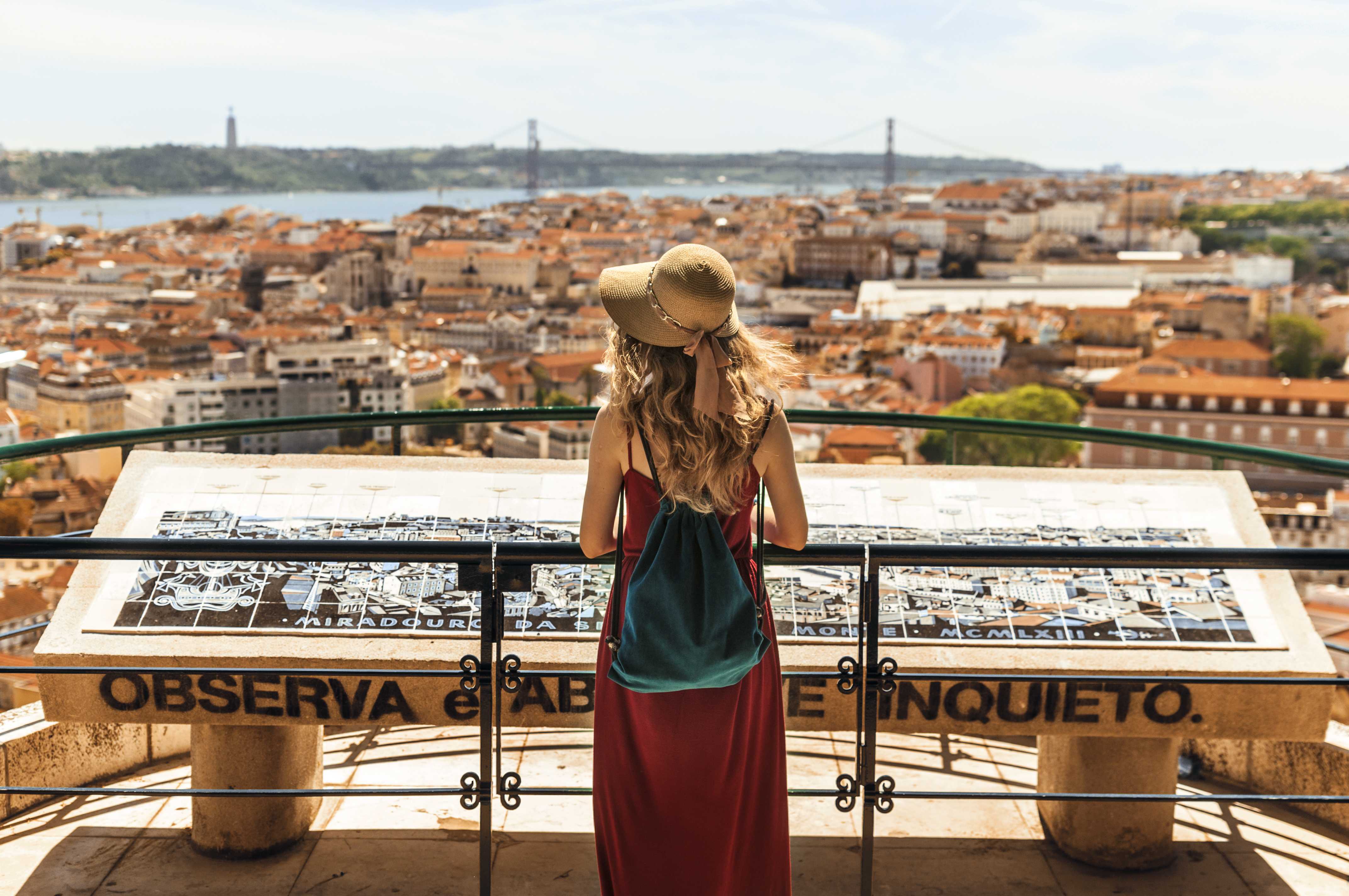 Woman at an overlook with a panoramic view of Lisbon and the Tagus River