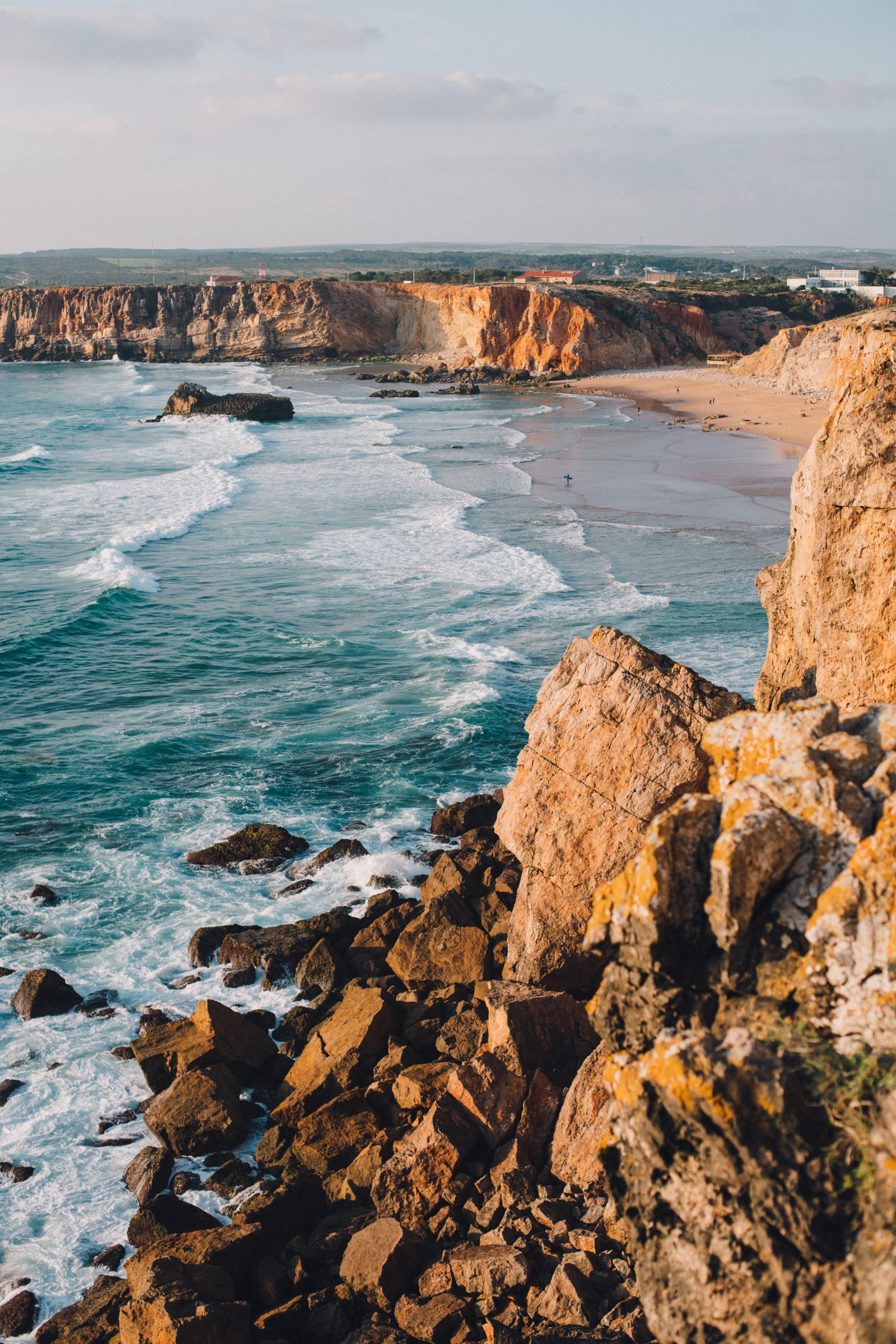 Scenic view of the Algarve coastline with rocky cliffs and ocean waves.