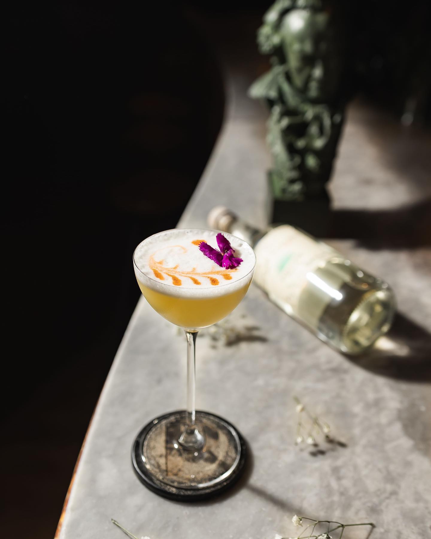 Craft cocktail presented on a marble countertop, with a mixology class in progress at Paradiso.