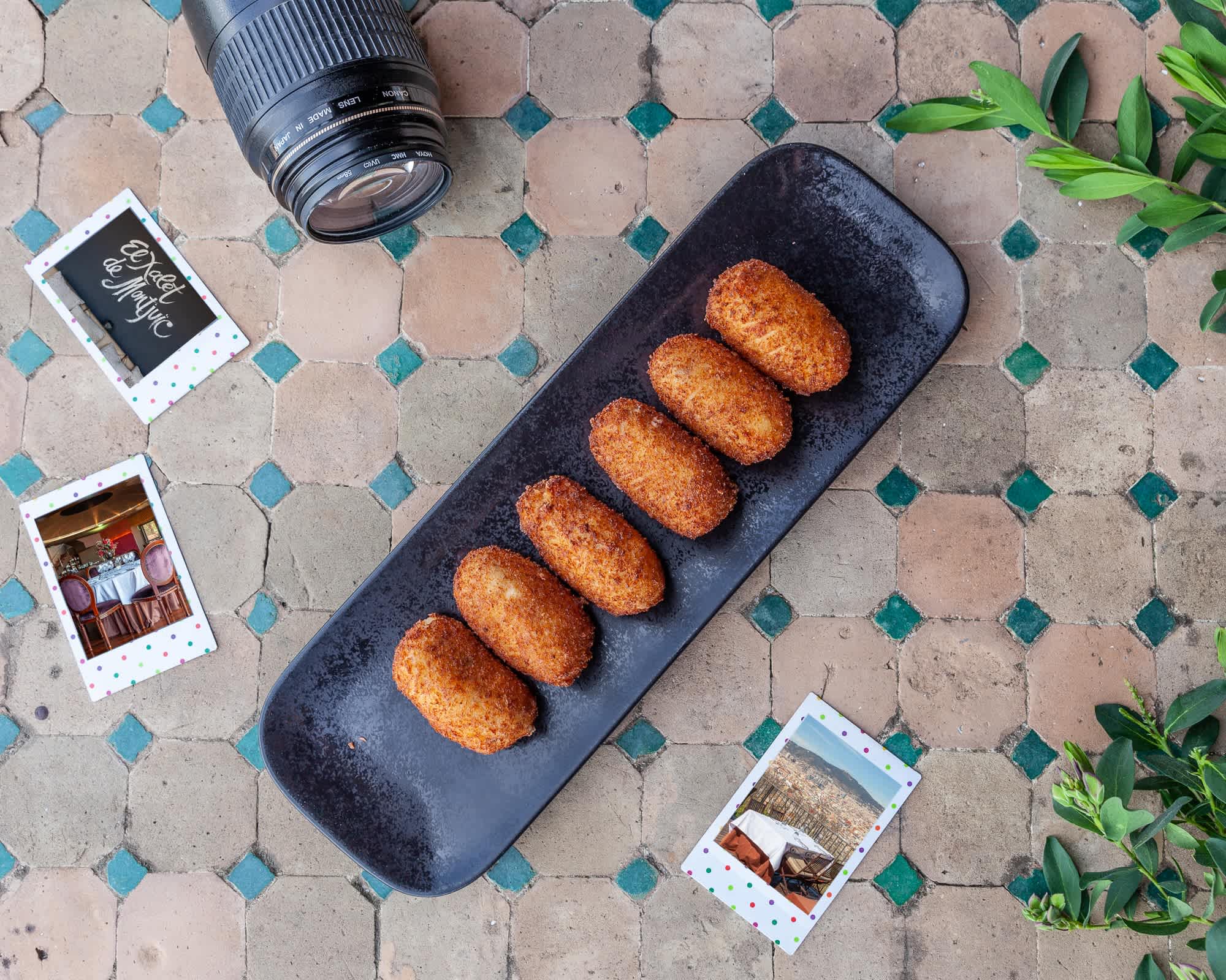 A plate of croquetas de jamón served on a dark slate tray.