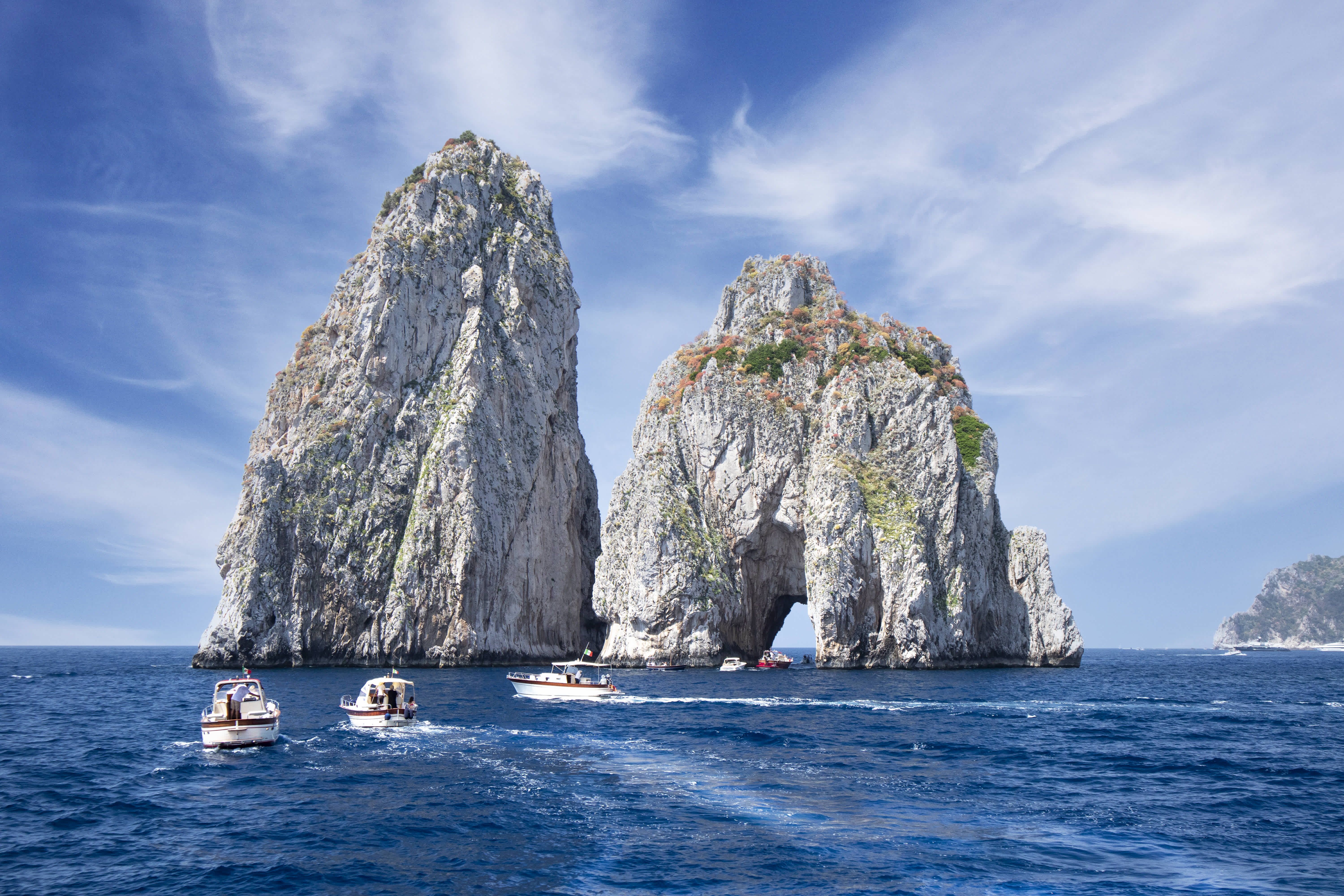 Boats sailing near the Faraglioni rock formations on the Amalfi Coast.