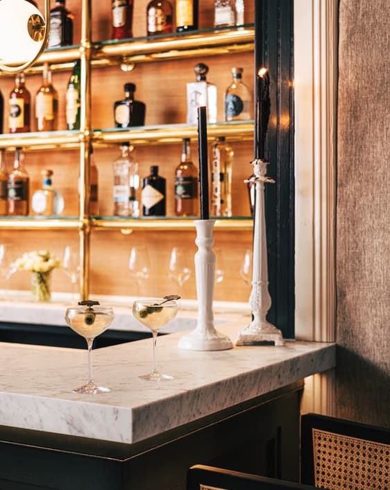 Bar with classic martini glasses and white candlesticks at Enchante Bistro in Hampton Bays.