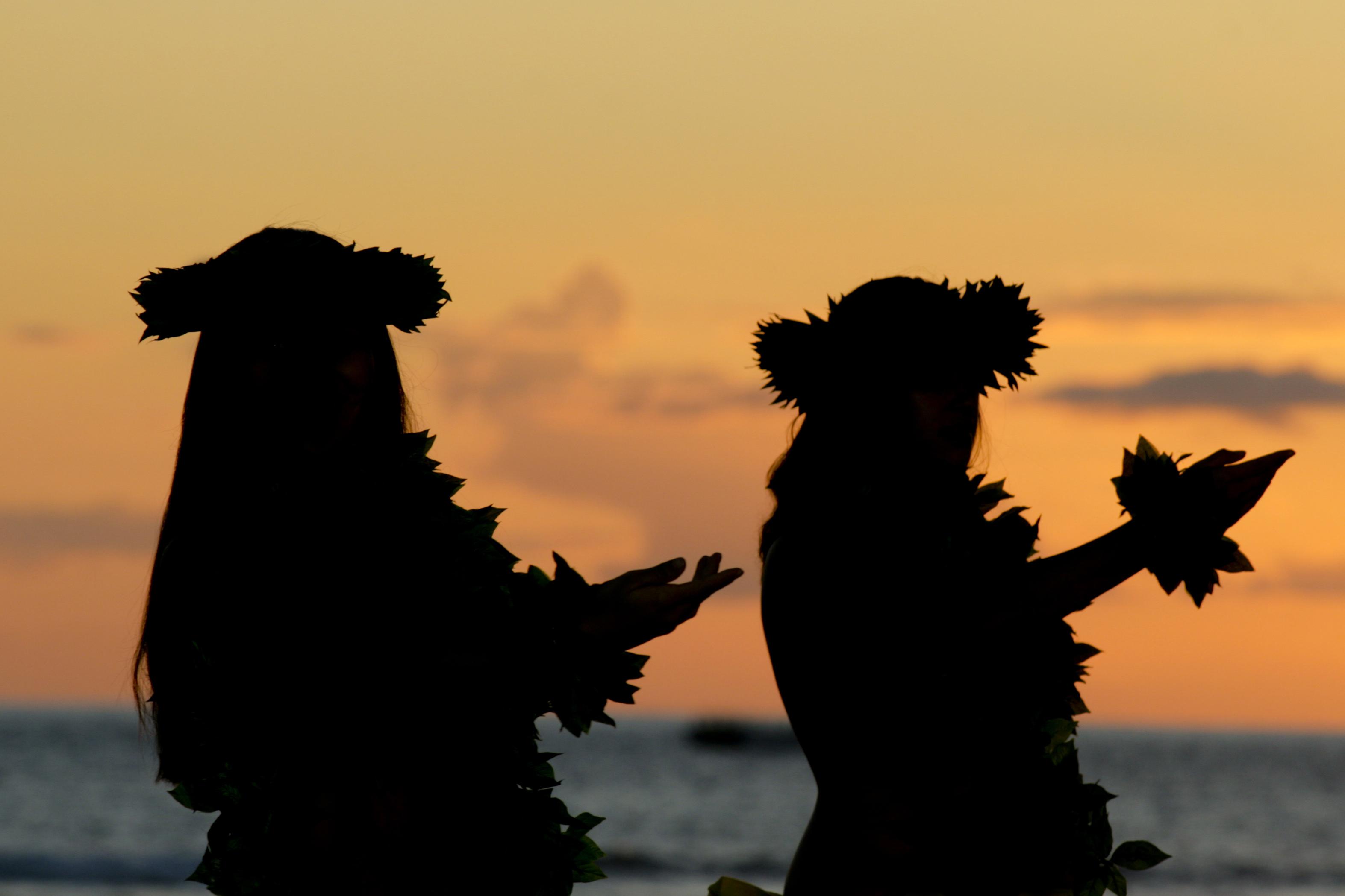 Silhouettes of hula dancers at sunset on the Kohala Coast.