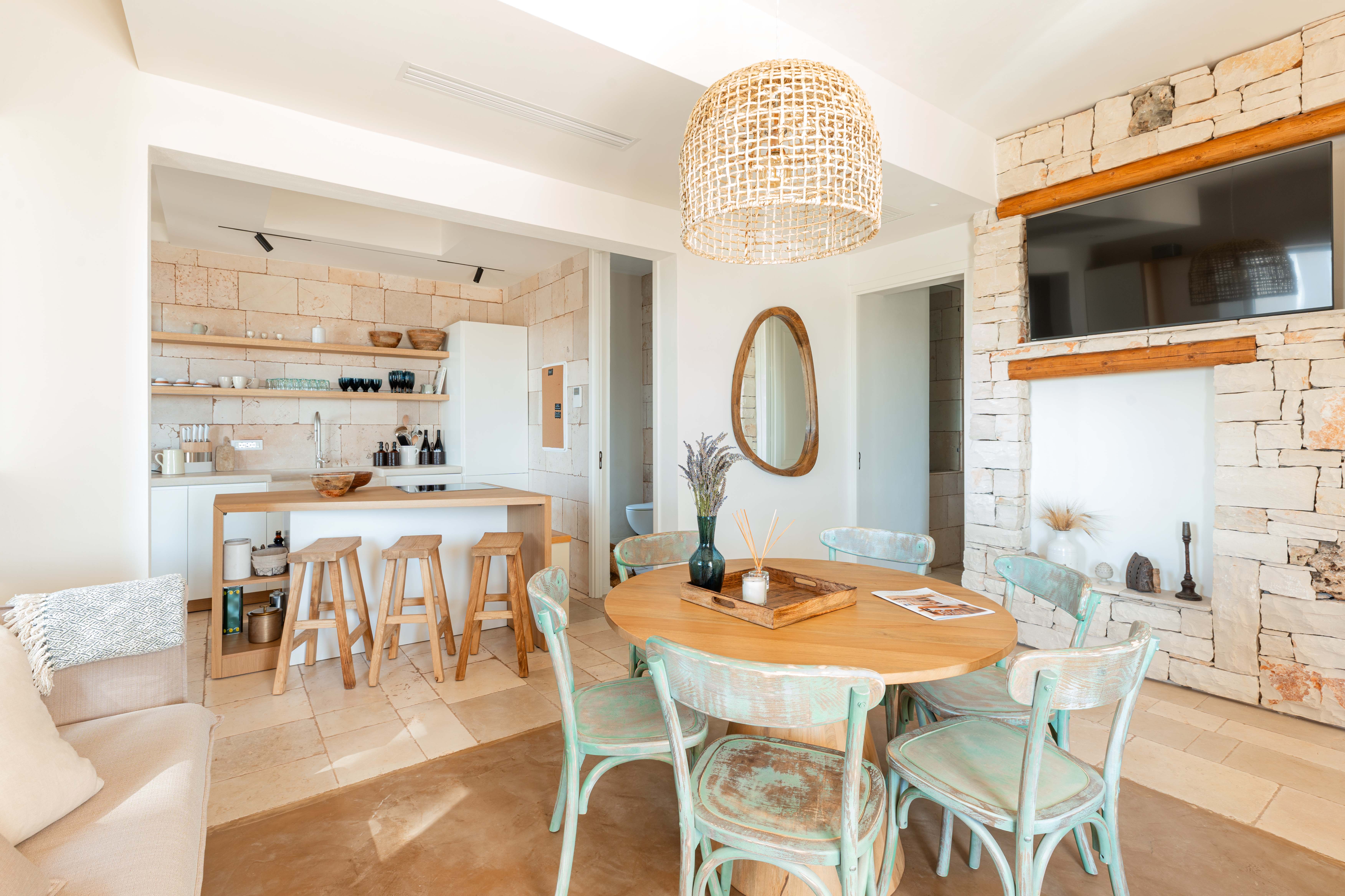 Exclusive Resorts' private villa in Puglia, Italy, featuring a rustic kitchen and dining area with stone walls and wooden accents.