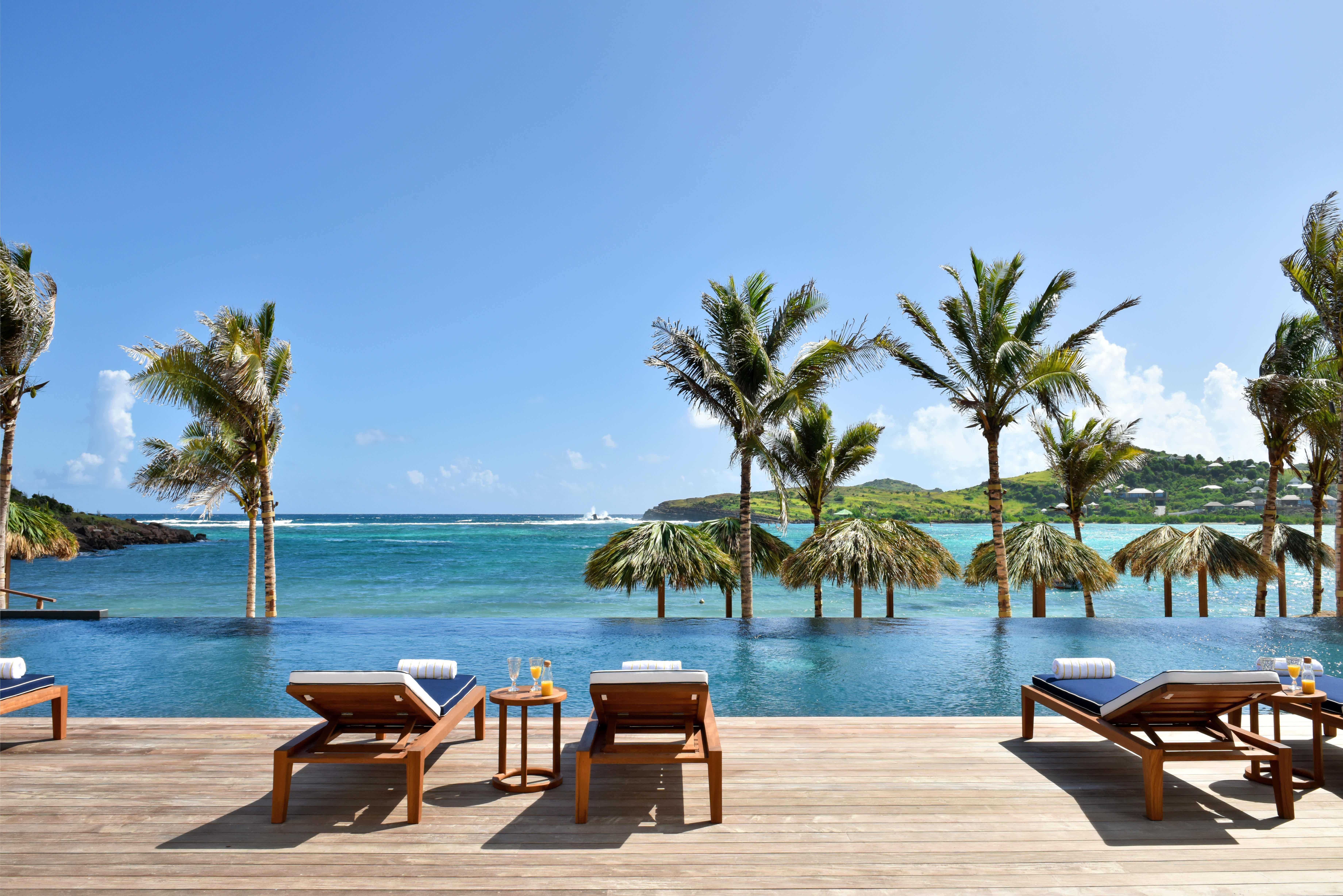 A serene view of the infinity pool overlooking the ocean at a Rosewood Le Guanahani St. Barth villa, an Exclusive Resorts property.