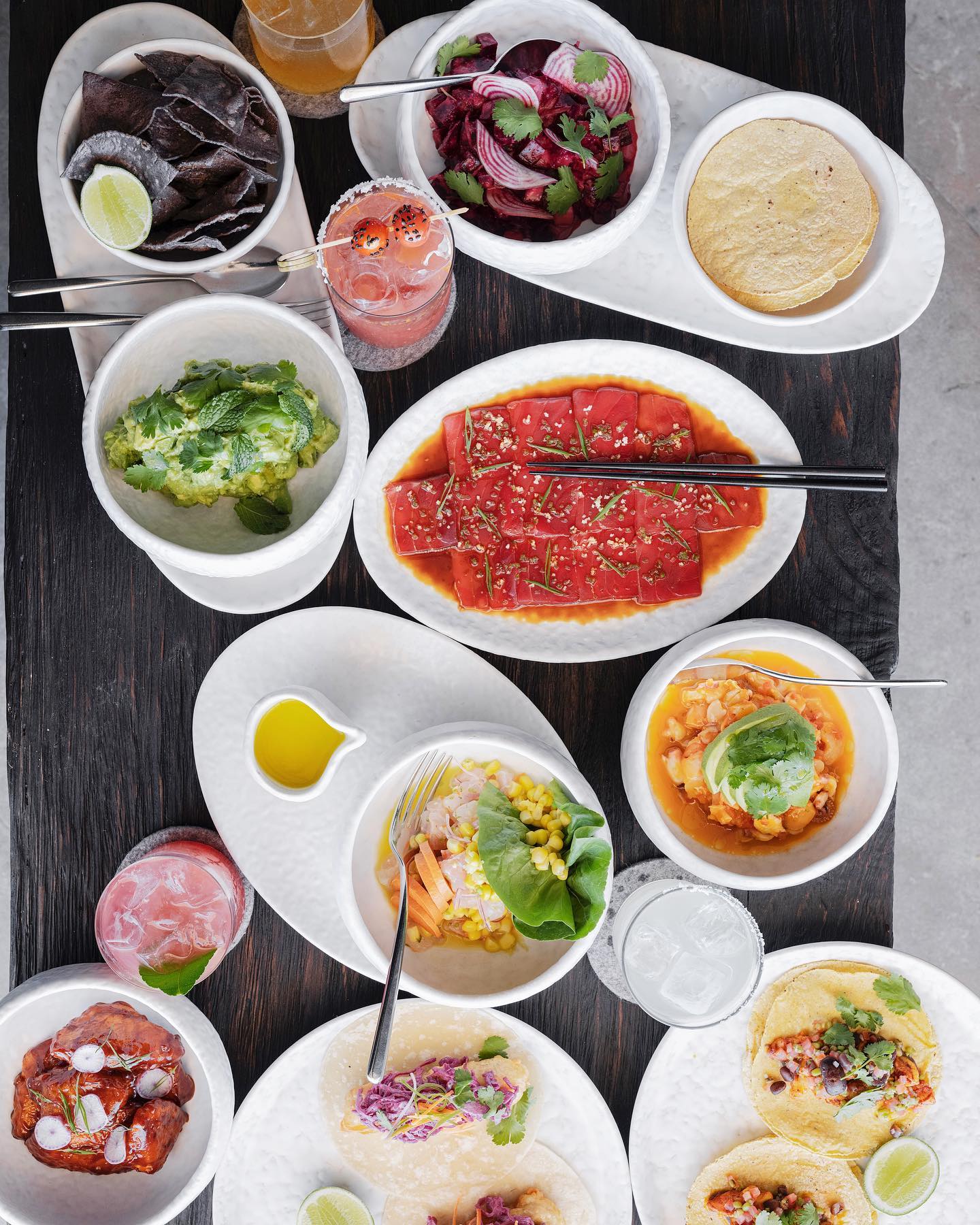 Table with several dishes and colorful drinks.