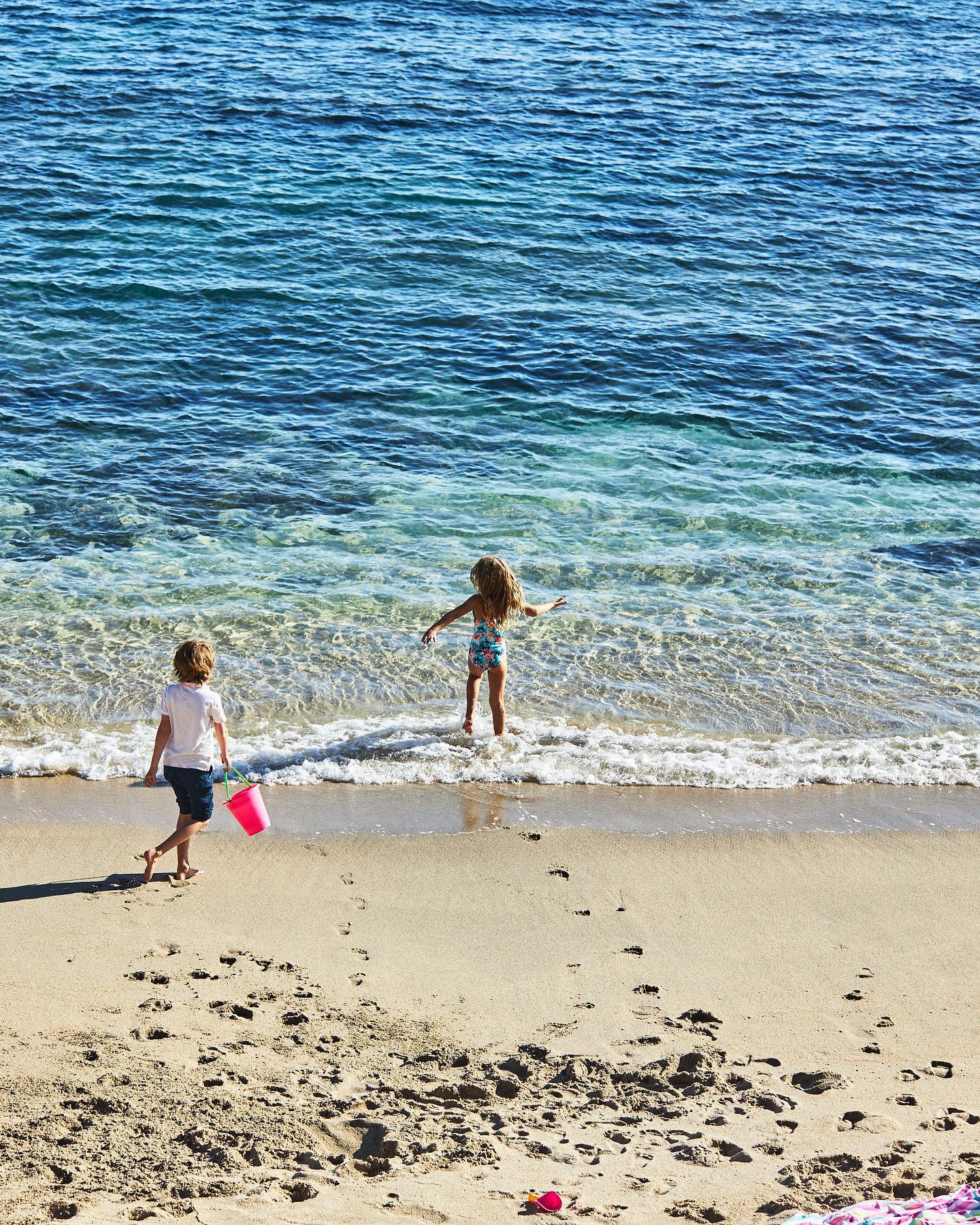 Two kids playing in the water in Los Cabos, Mexico.