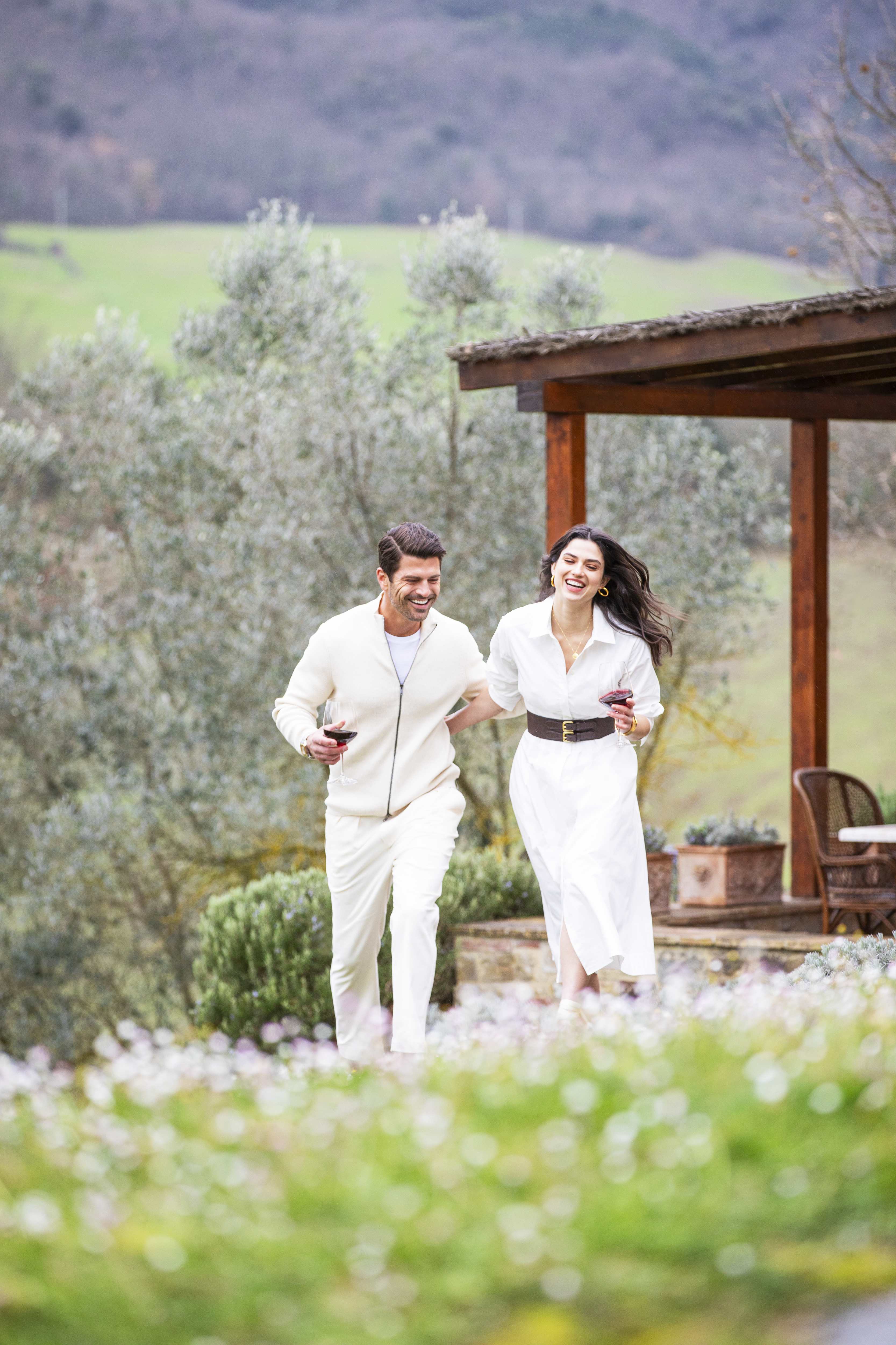 Members of the vacation club Exclusive Resorts enjoying a walk with wine glasses at a private home in Tuscany, Italy.