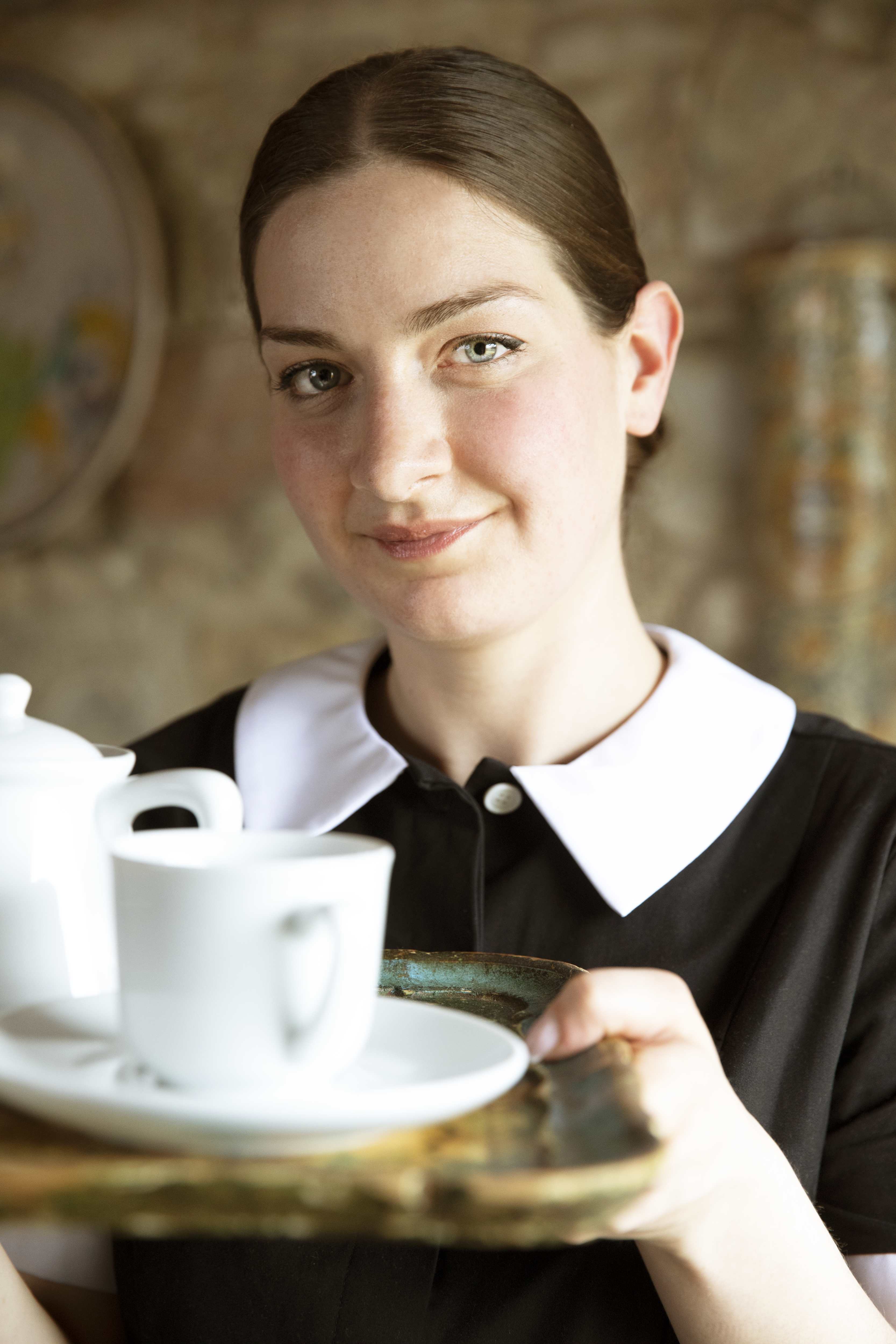 On-site concierge with a cup of tea at an Exclusive Resorts private villa in Tuscany, Italy.