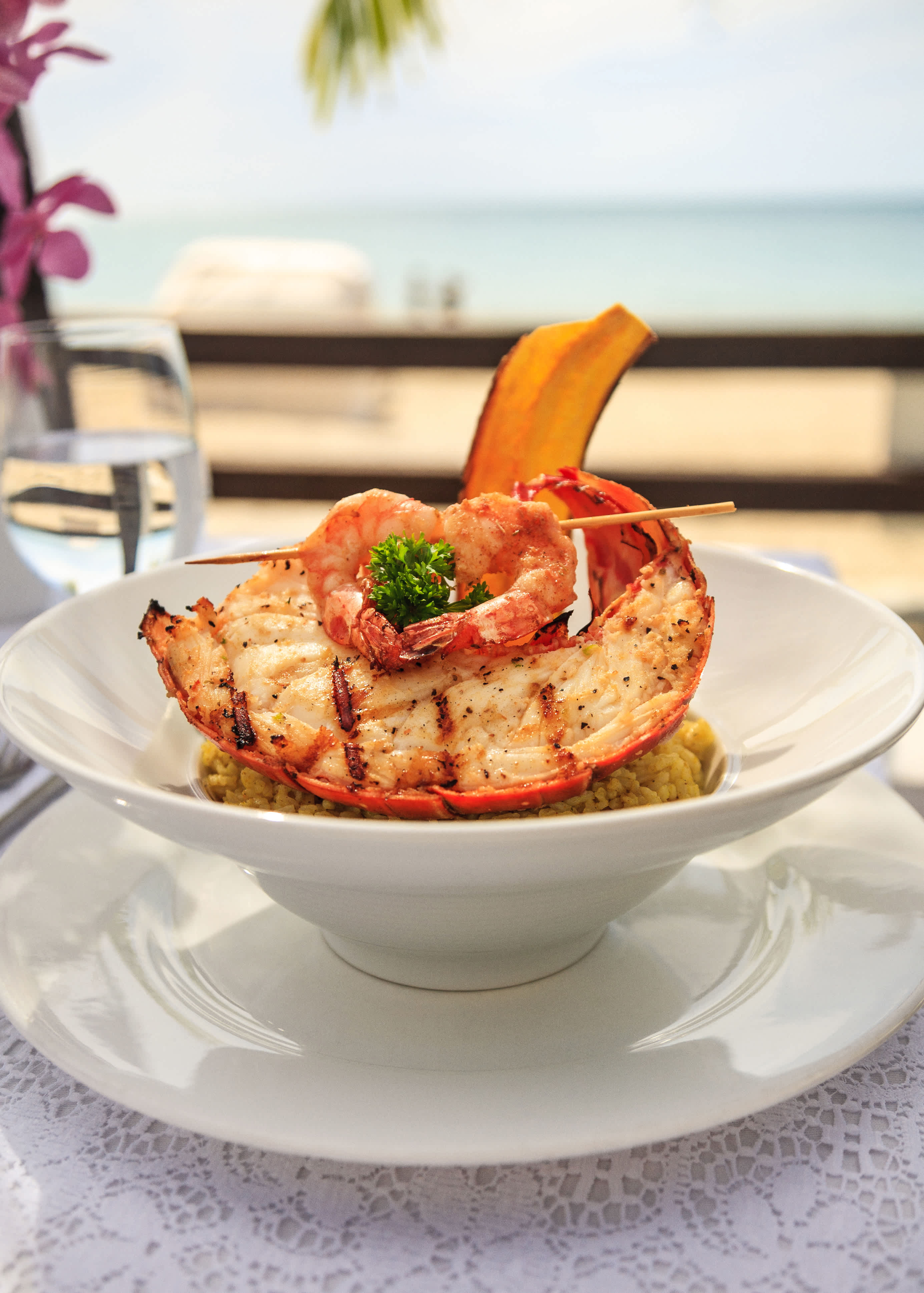 Gourmet seafood dish served with ocean view in the background