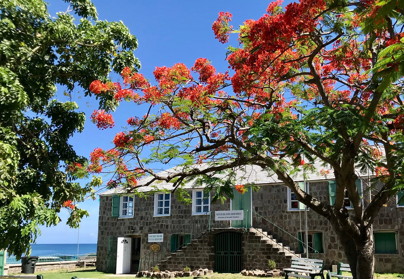 Charming beachside cottage surrounded by vibrant foliage at the Museum of Nevis History