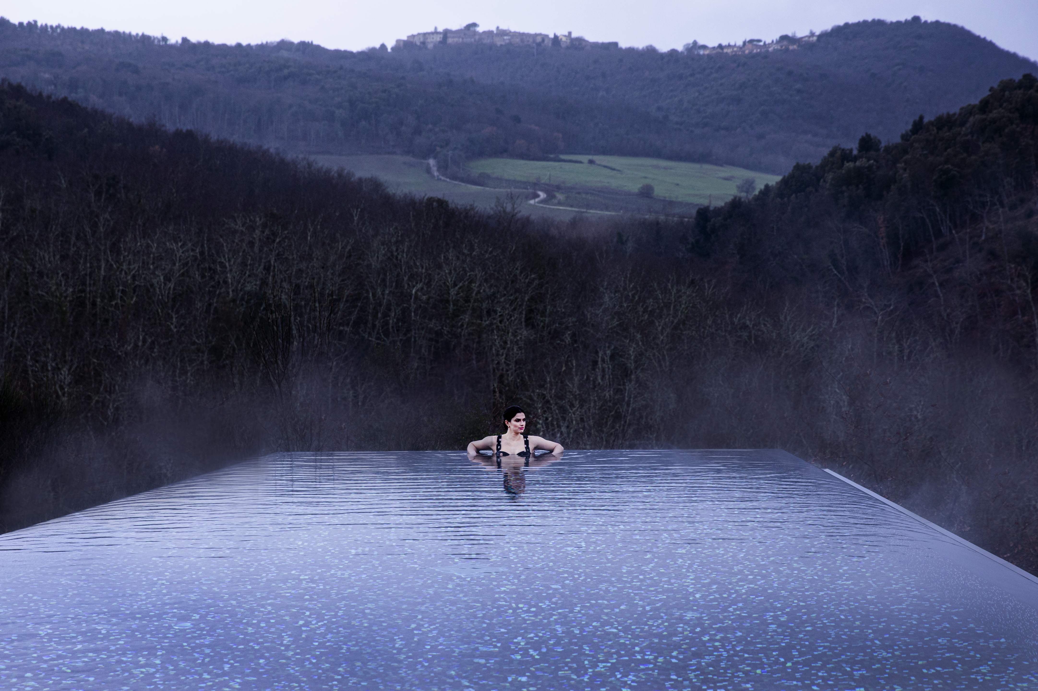 A member of the vacation club Exclusive Resorts enjoying a serene infinity pool at a private home in Tuscany, Italy.