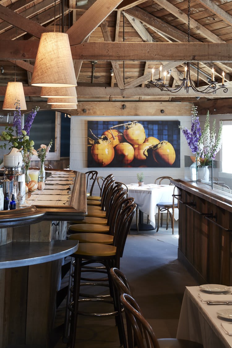 Interior of Angele Restaurant & Bar in Napa Valley with wooden decor and fruit painting