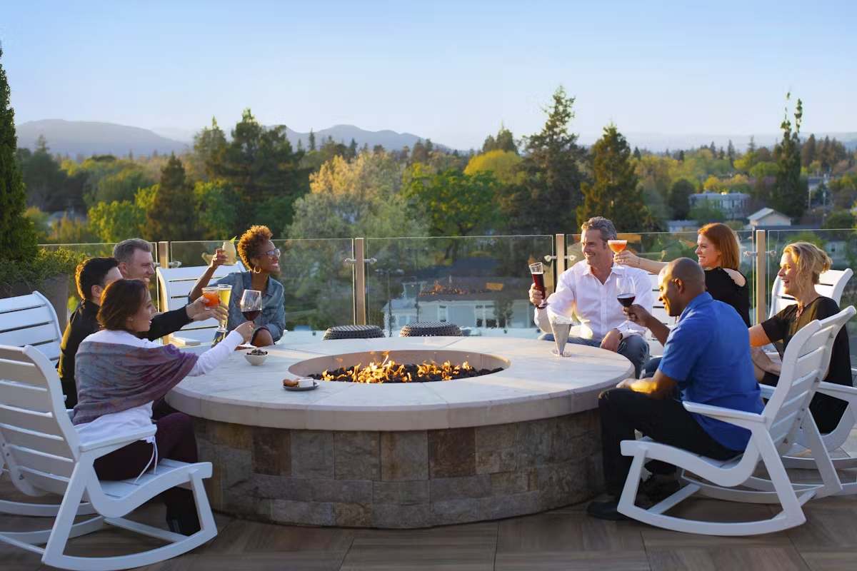 Group of people sitting around a fire pit with scenic views in Napa Valley