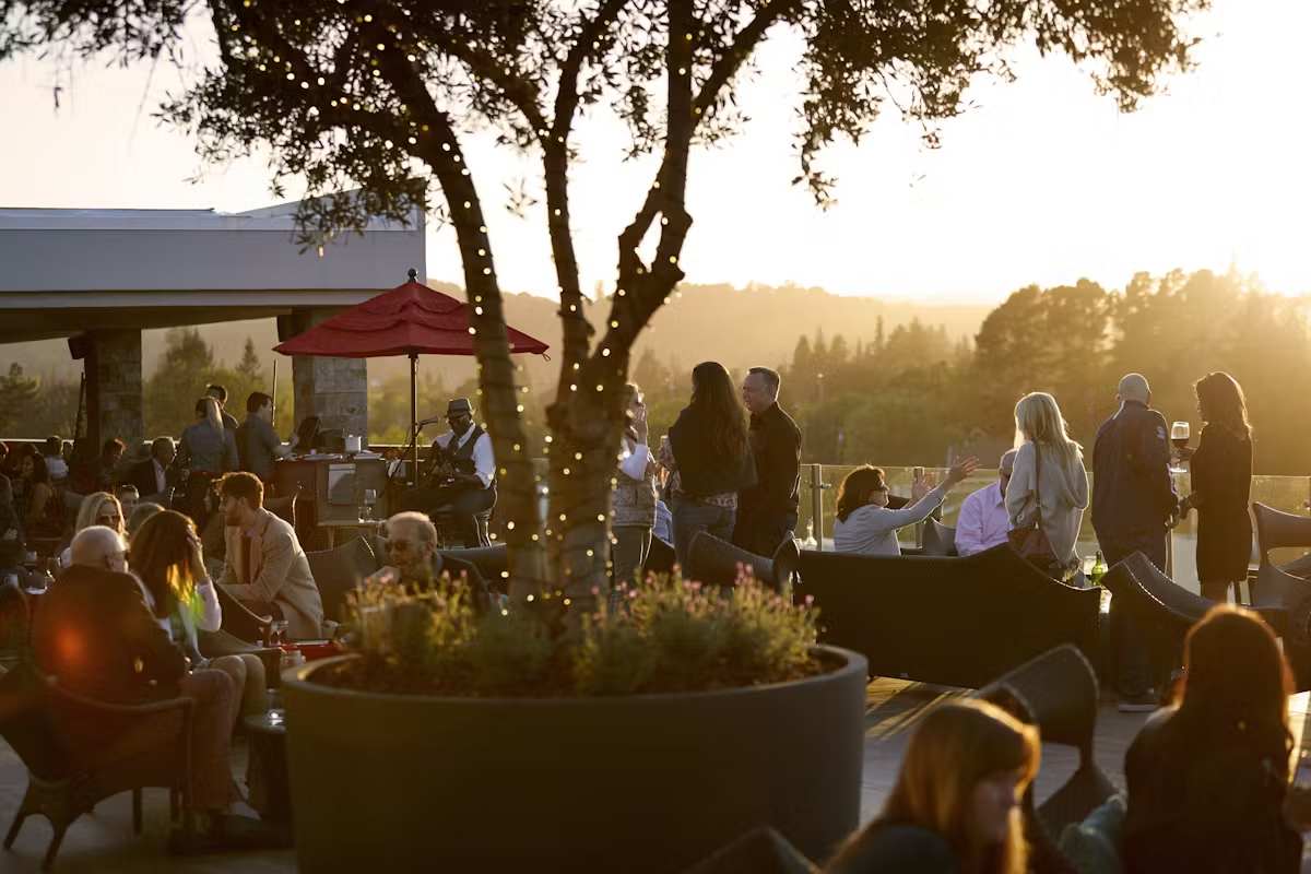 People enjoying an outdoor gathering at sunset in Napa Valley