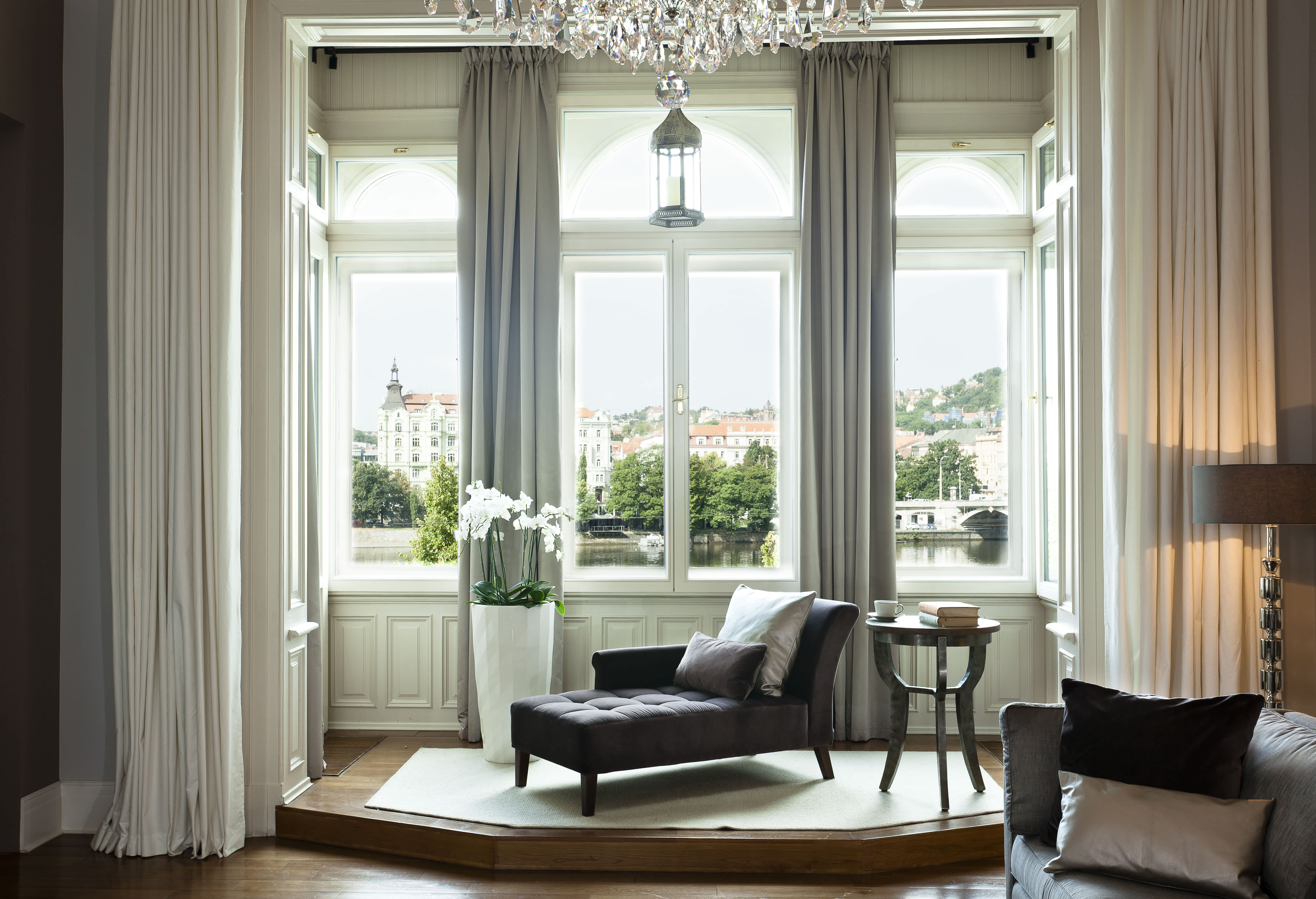 Exclusive Resorts' private villa in Prague with a luxurious lounge area and panoramic city views through large windows.