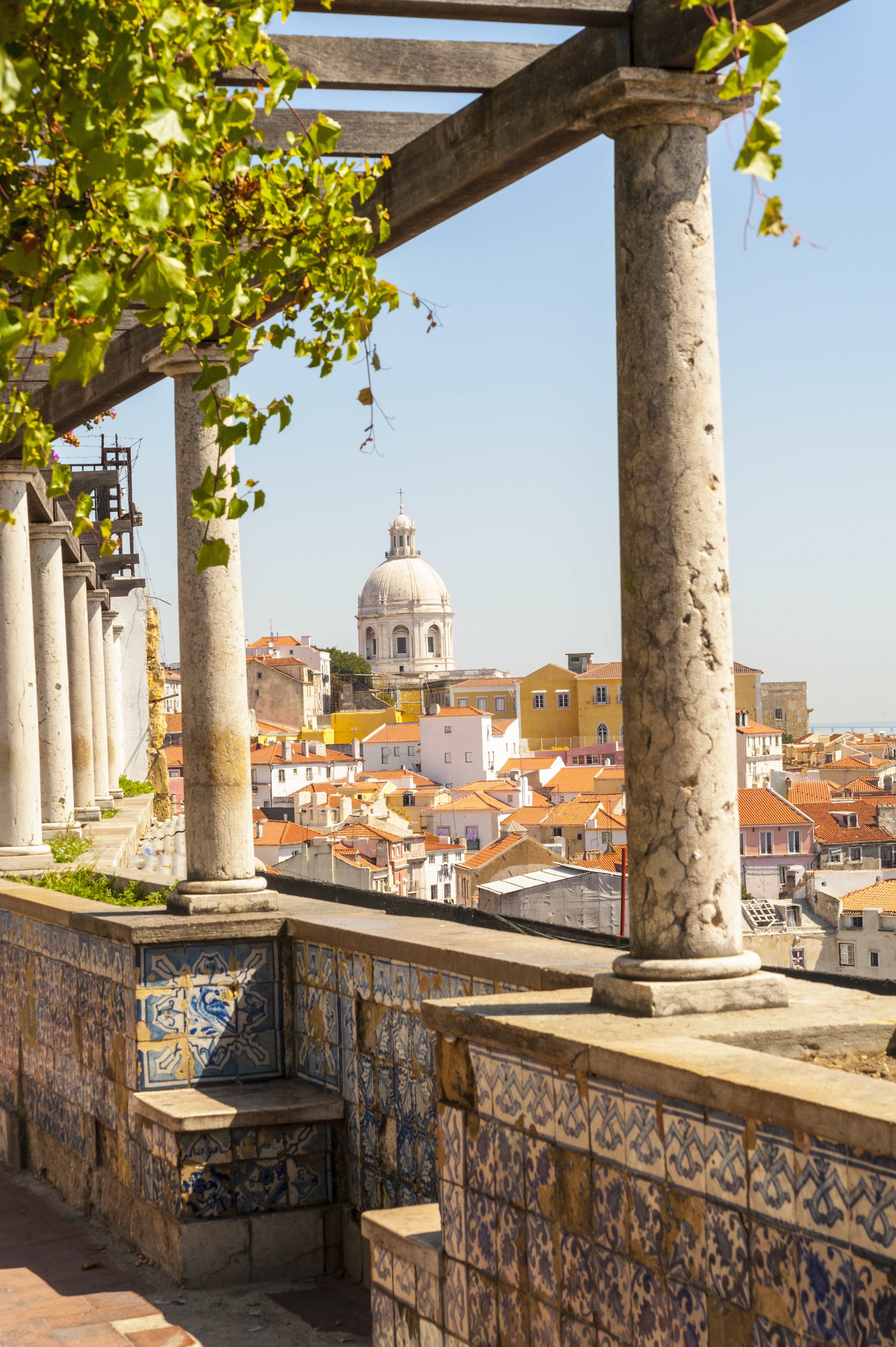 Scenic view of Lisbon with colorful buildings, framed by columns with decorative tiles