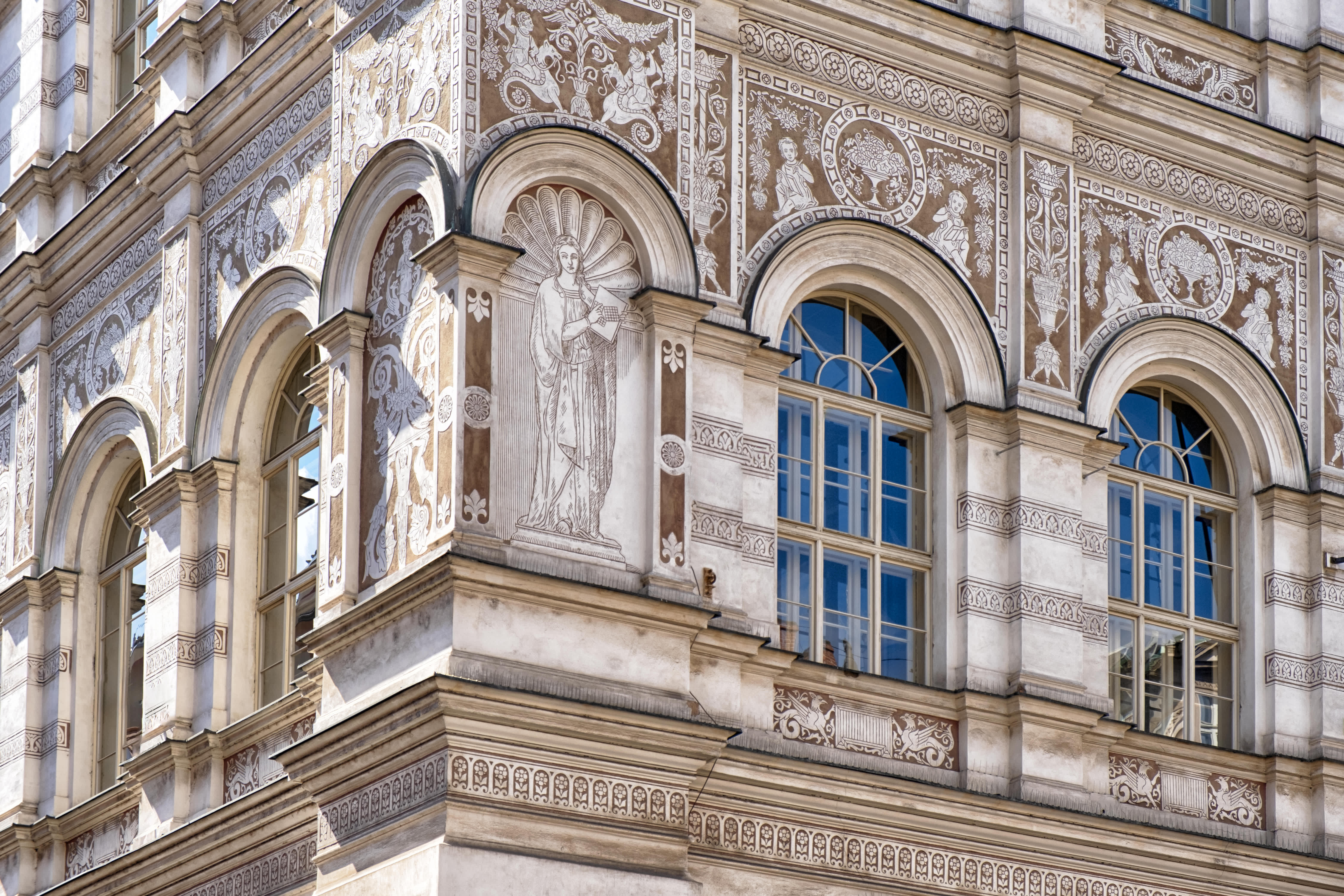 Ornate facade with detailed artwork and arched windows at Charles University in Prague, Czech Republic
