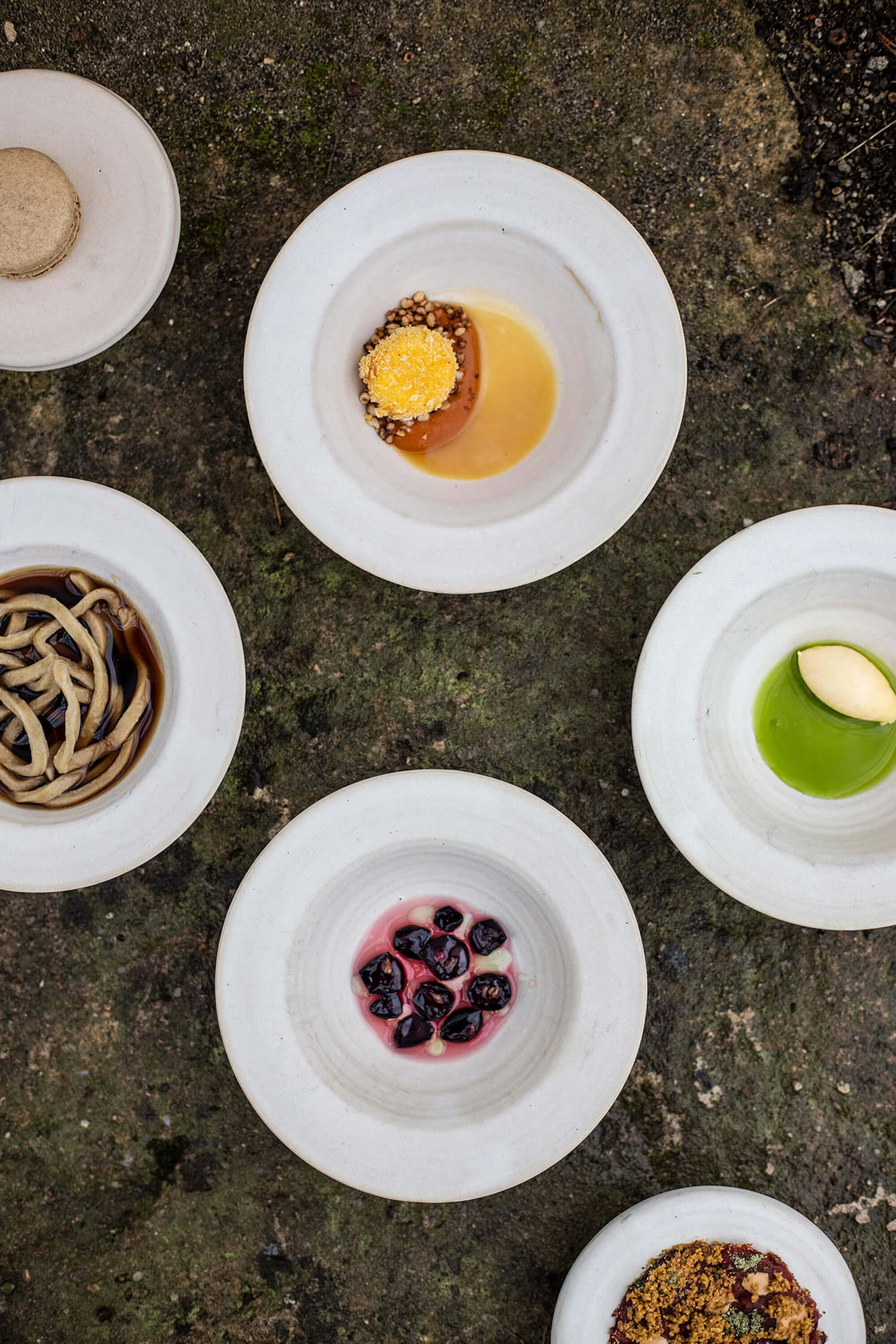 An assortment of plated dishes arranged on a textured surface at Ze Me Restaurant in Prague