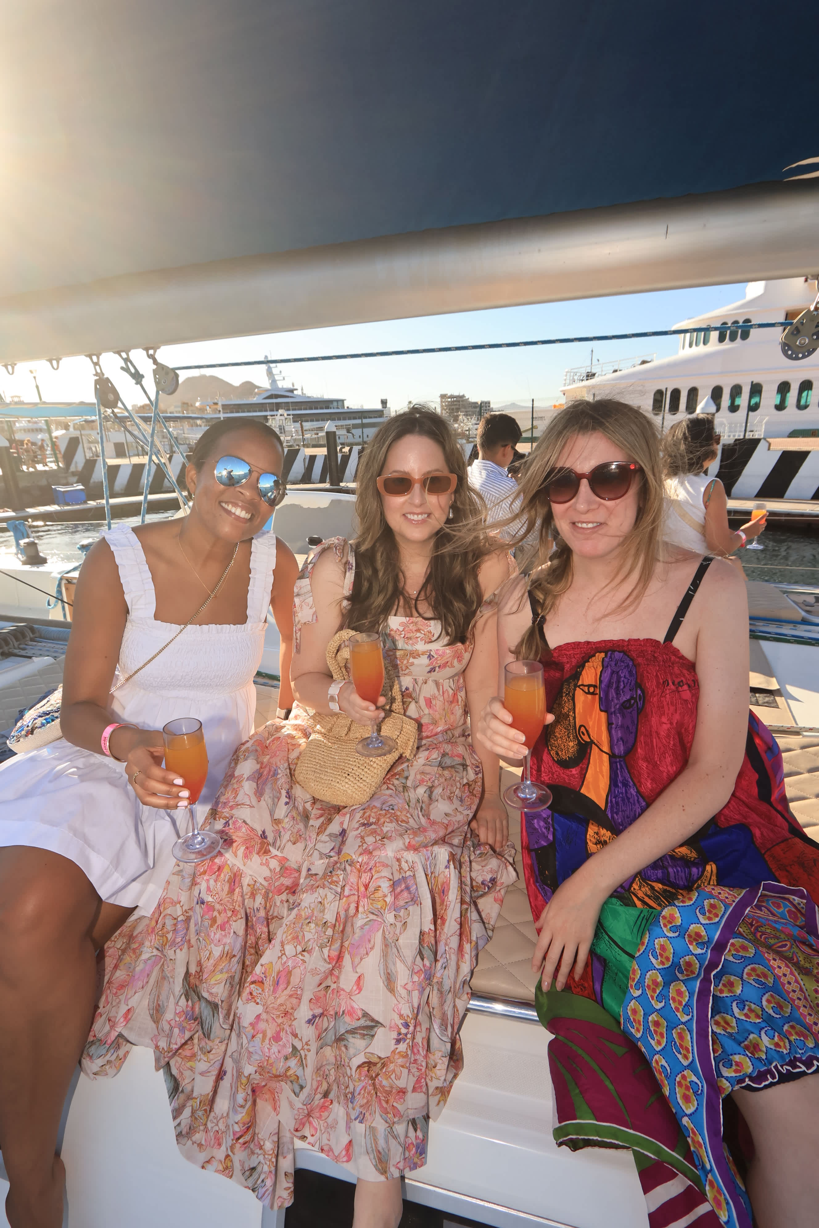 Three women on a yacht, enjoying a summer drink in Los Cabos.